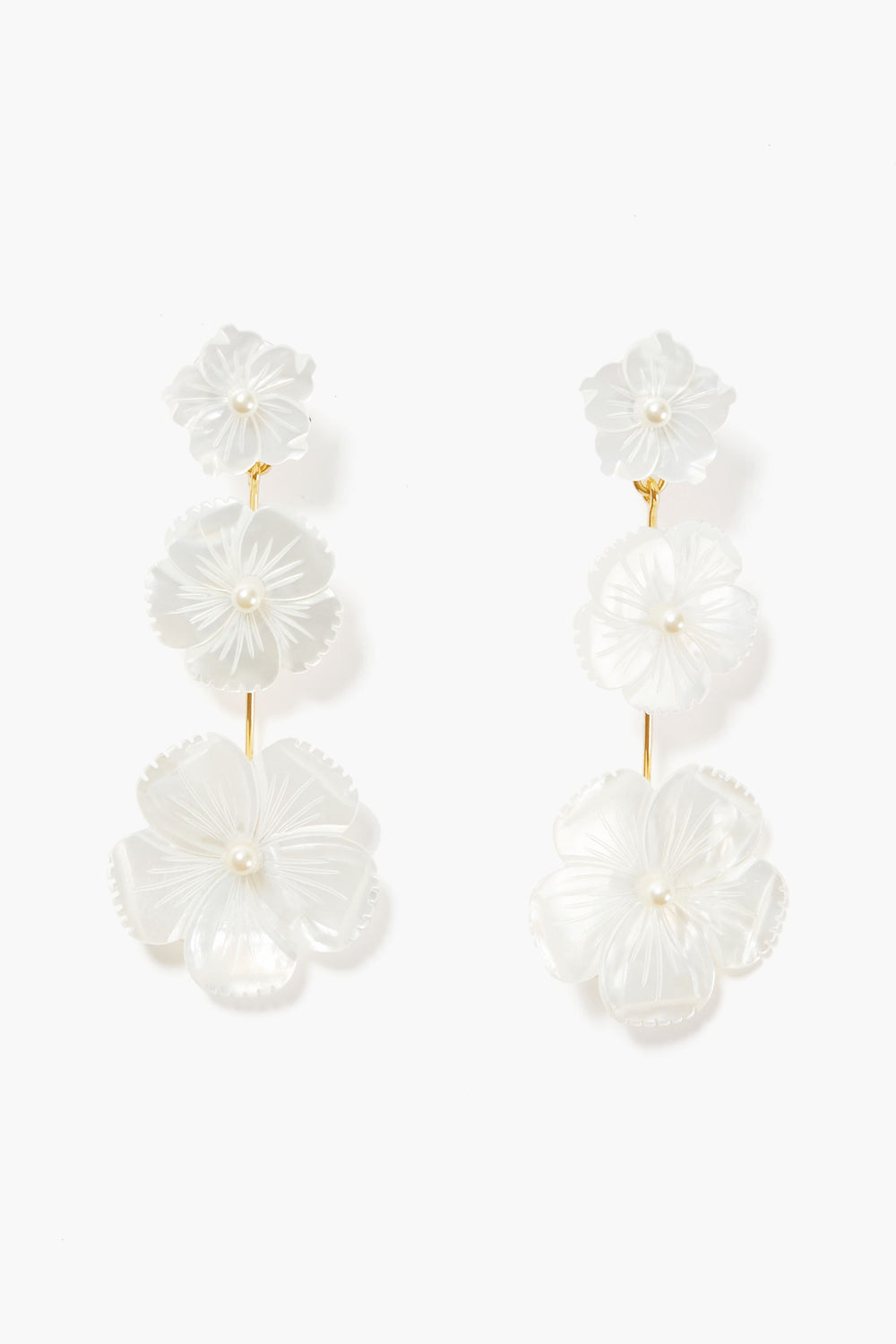 Jennifer Behr floral drop earrings feature three white carved flowers with pearl centers, linked by gold-toned metal and handmade in New York.