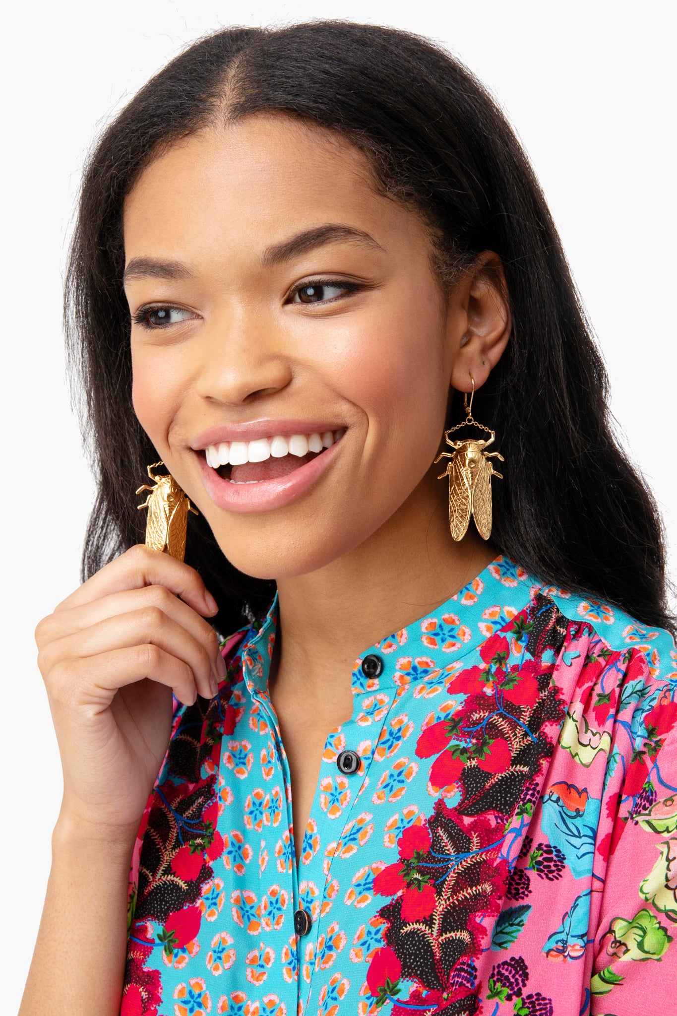 Young woman wearing classic, oversized Goldbug Large Drop Earrings with a cicada design, embodying a fun and high-end Charleston-inspired style, effortlessly complementing her floral-print shirt.