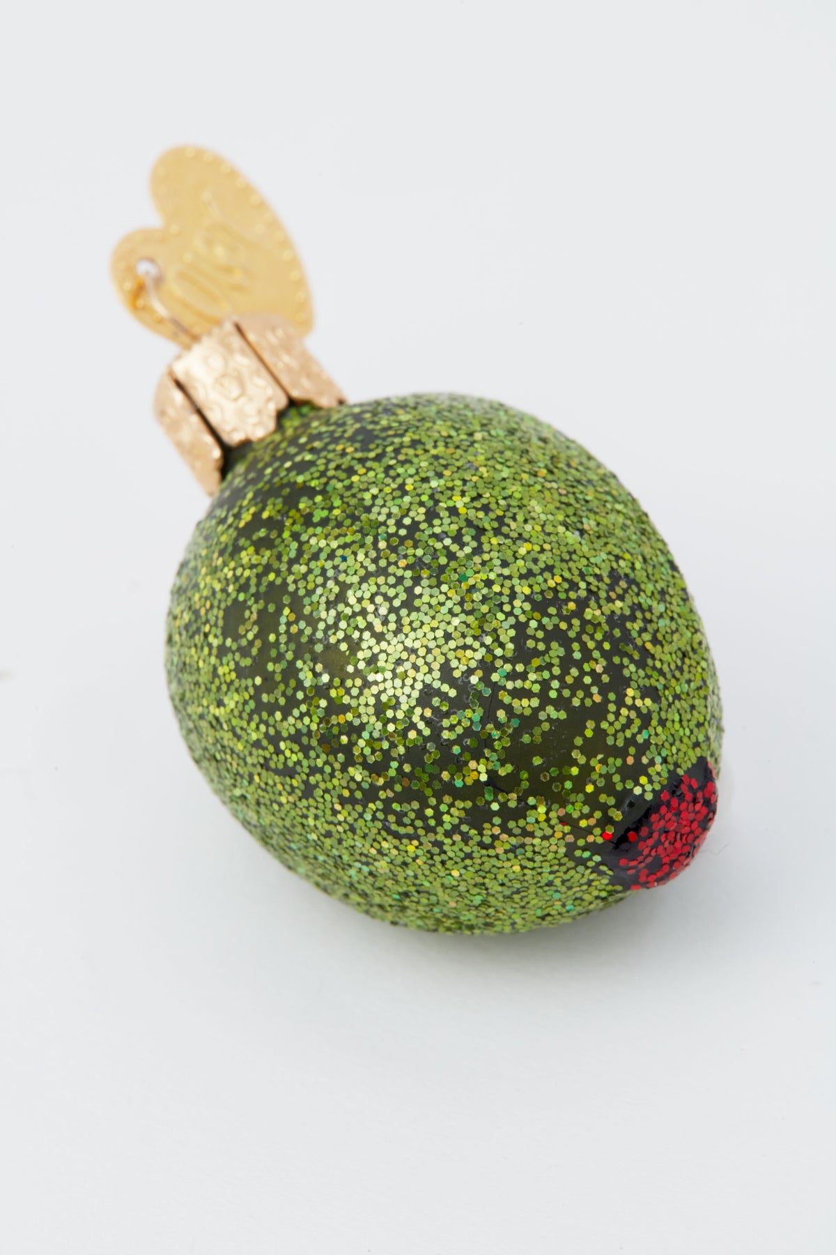 Old World Christmas glass-blown green olive ornament features a glittery finish, red pimento, and gold cap—perfect for any dirty martini fan’s holiday décor.