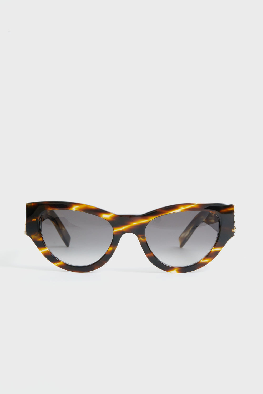 Saint Laurent tortoiseshell cat-eye sunglasses with dark gradient lenses, displayed in a minimalist setting.