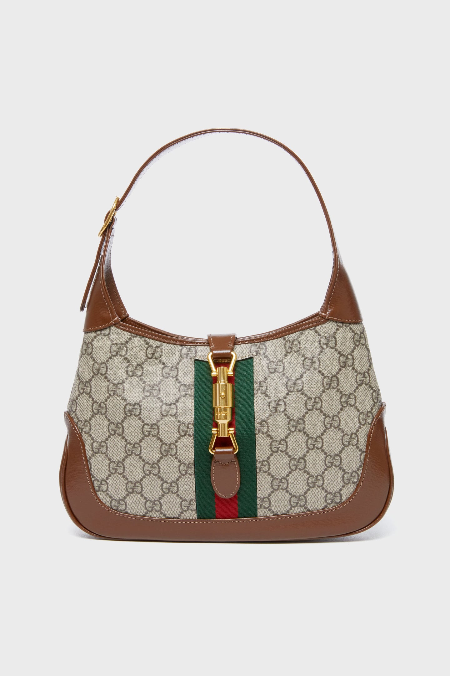 A Tuckernuck Archive Collection shoulder bag with brown leather trim, beige canvas featuring a monogram, green and red stripe detail, and a gold clasp—an elegant accessory from the distinctive collection.