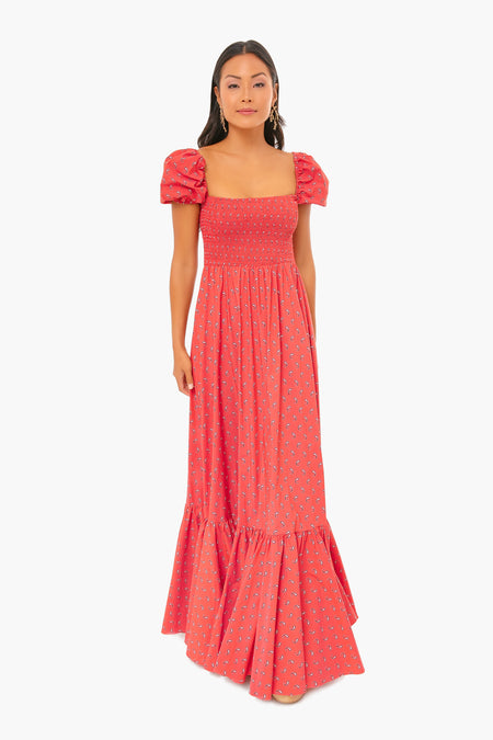 A woman stands confidently facing forward in a Caroline Constas red floral-print Gianna Dress, featuring short puff sleeves and a square neckline.