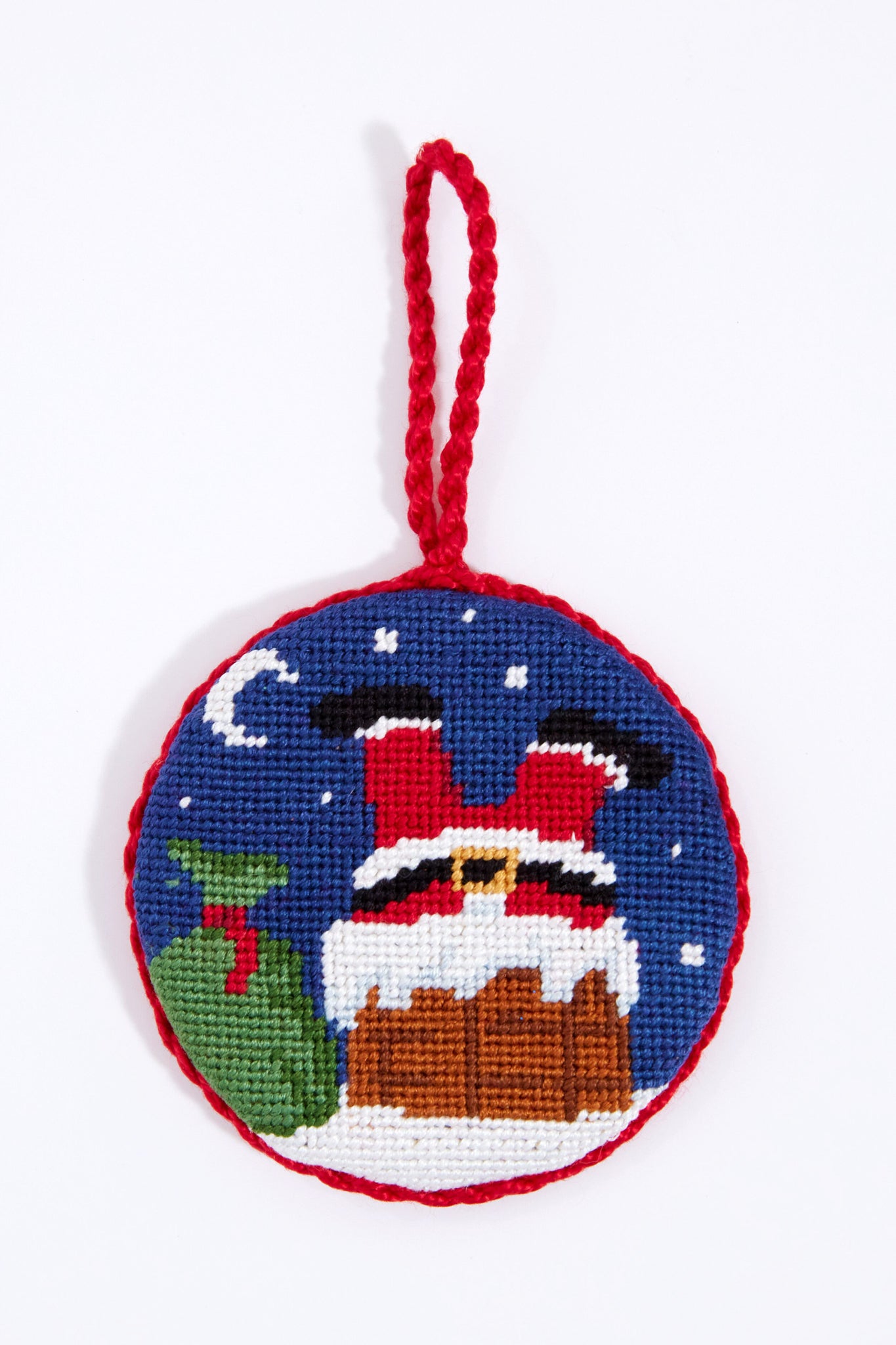 Smathers and Branson Round Santa Needlepoint Ornament features a hand-stitched design with Santa’s legs in a chimney, green sack, snow, and moon, finished with a red braided loop—a charming holiday accent for your tree.