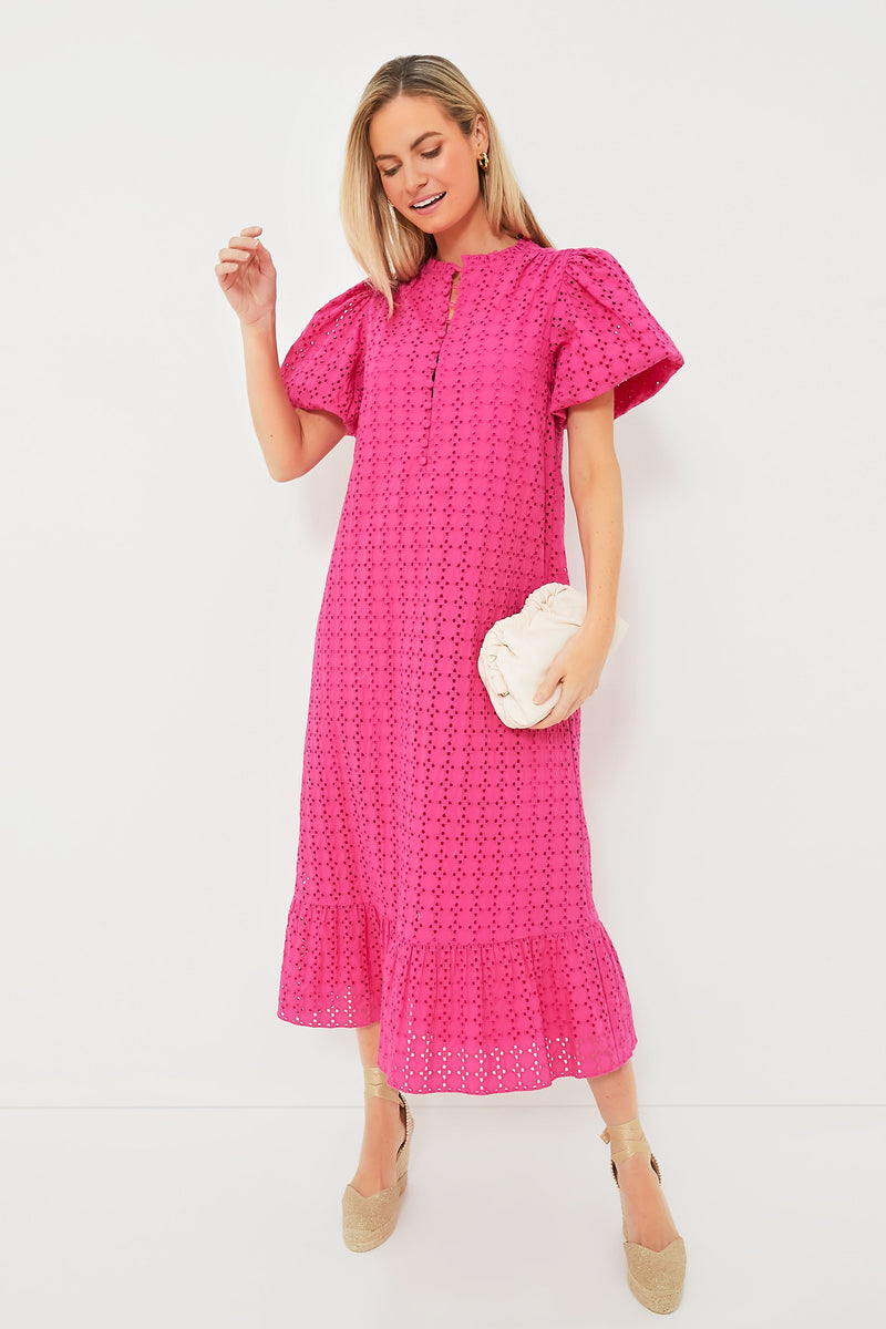 A woman wears a Hyacinth House Pink Eyelet Midi Dress with puff sleeves and beige espadrille wedges, holding a light-colored clutch.