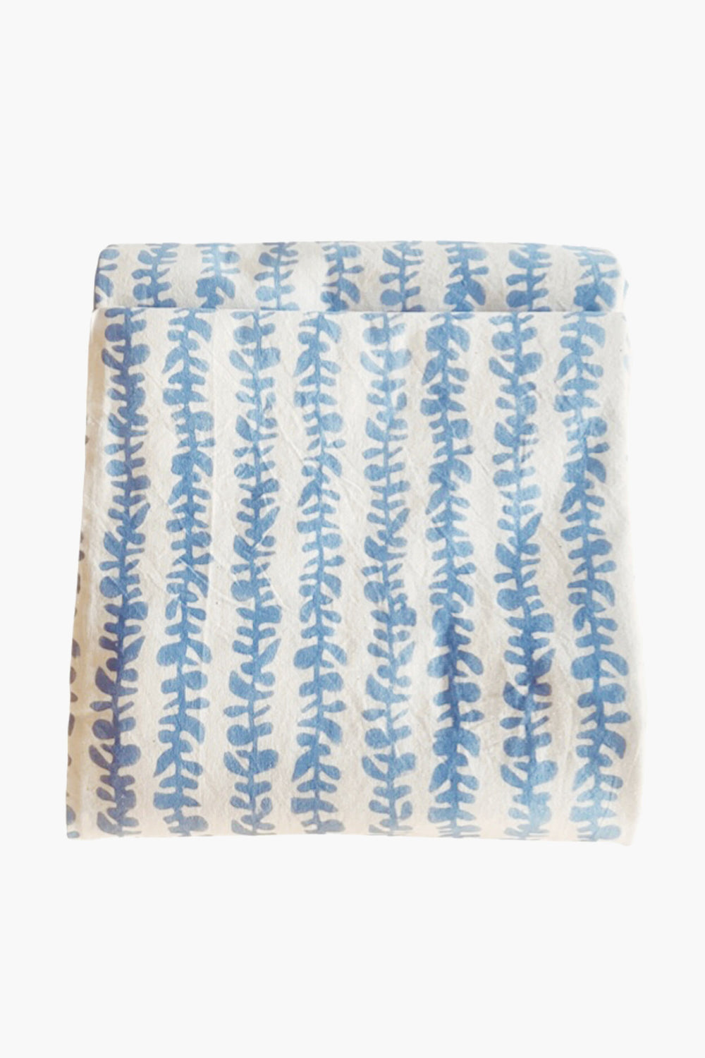 Folded white blanket by Modafleur featuring a blue leaf-like vertical pattern, reminiscent of botanical or block-printed table linens.