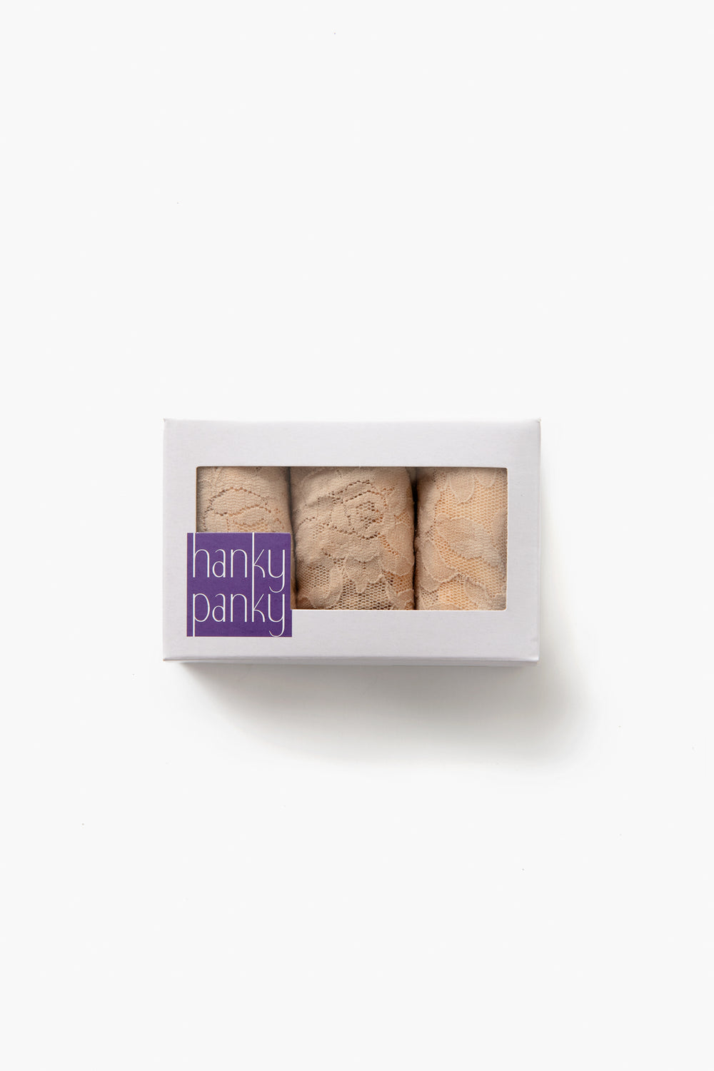 A white box with a clear window displays three pairs of Hanky Panky signature lace thongs. The box features a purple label and offers women’s lingerie designed for no visible panty lines.