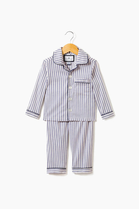 Petite Plume’s children’s navy French ticking pajama set, with long sleeves and pants, is made from cotton for cozy comfort. Shown on a wooden hanger, these pajamas offer soft sleepwear perfect for kids' restful nights.