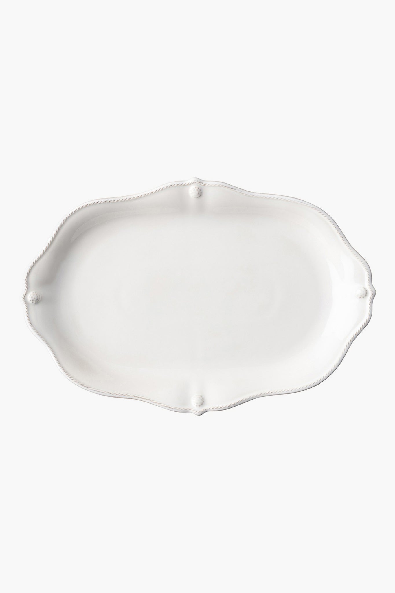 Juliska's empty, white oval ceramic stoneware platter features a scalloped edge and subtle embossed detailing—perfect for adding elegance to your dinnerware collection.