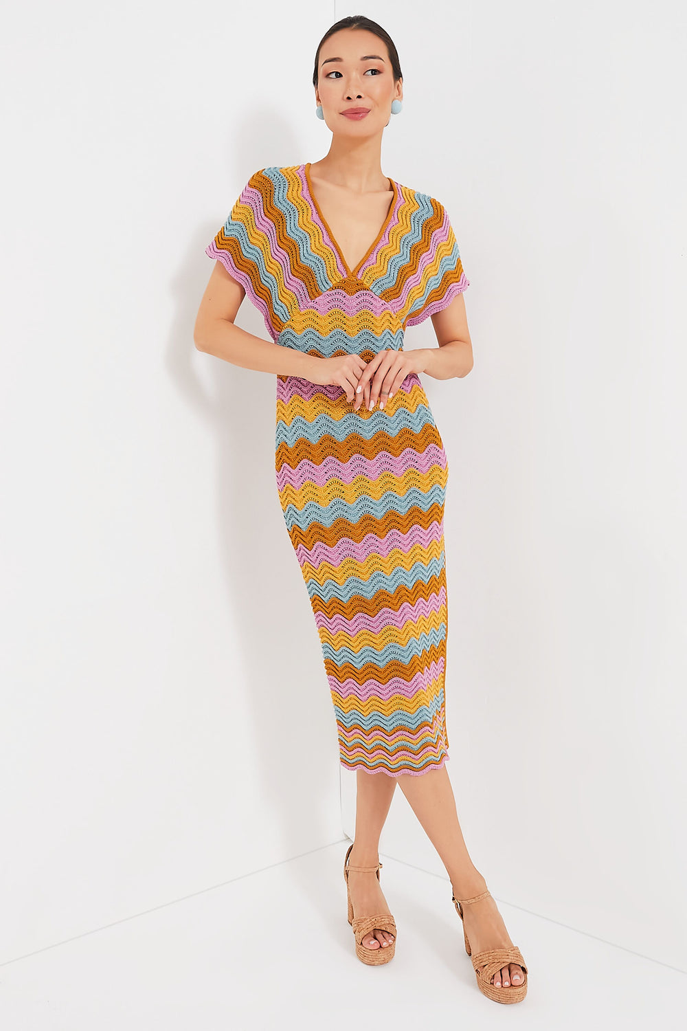 A woman wears a colorful, zigzag-patterned short-sleeve summer dress by Saylor, paired with tan heeled sandals.