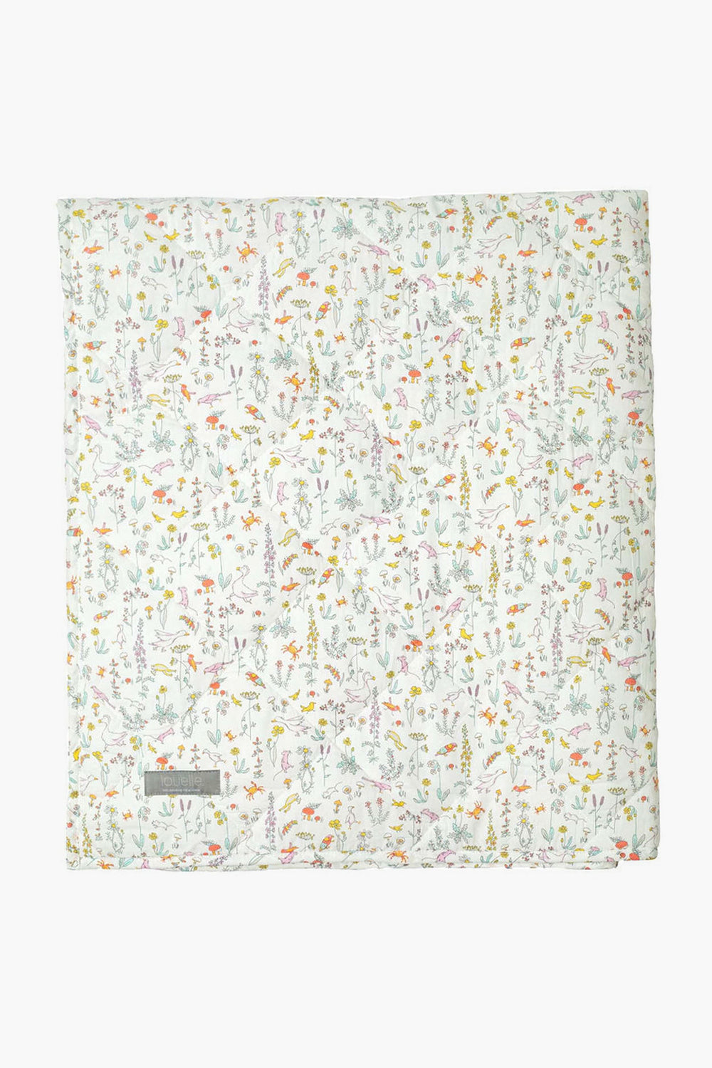 A folded Louelle. white quilt with a colorful floral pattern, small flowers and leaves, plus a gray corner label makes a charming linen play mat—ideal for luxury baby gifts.