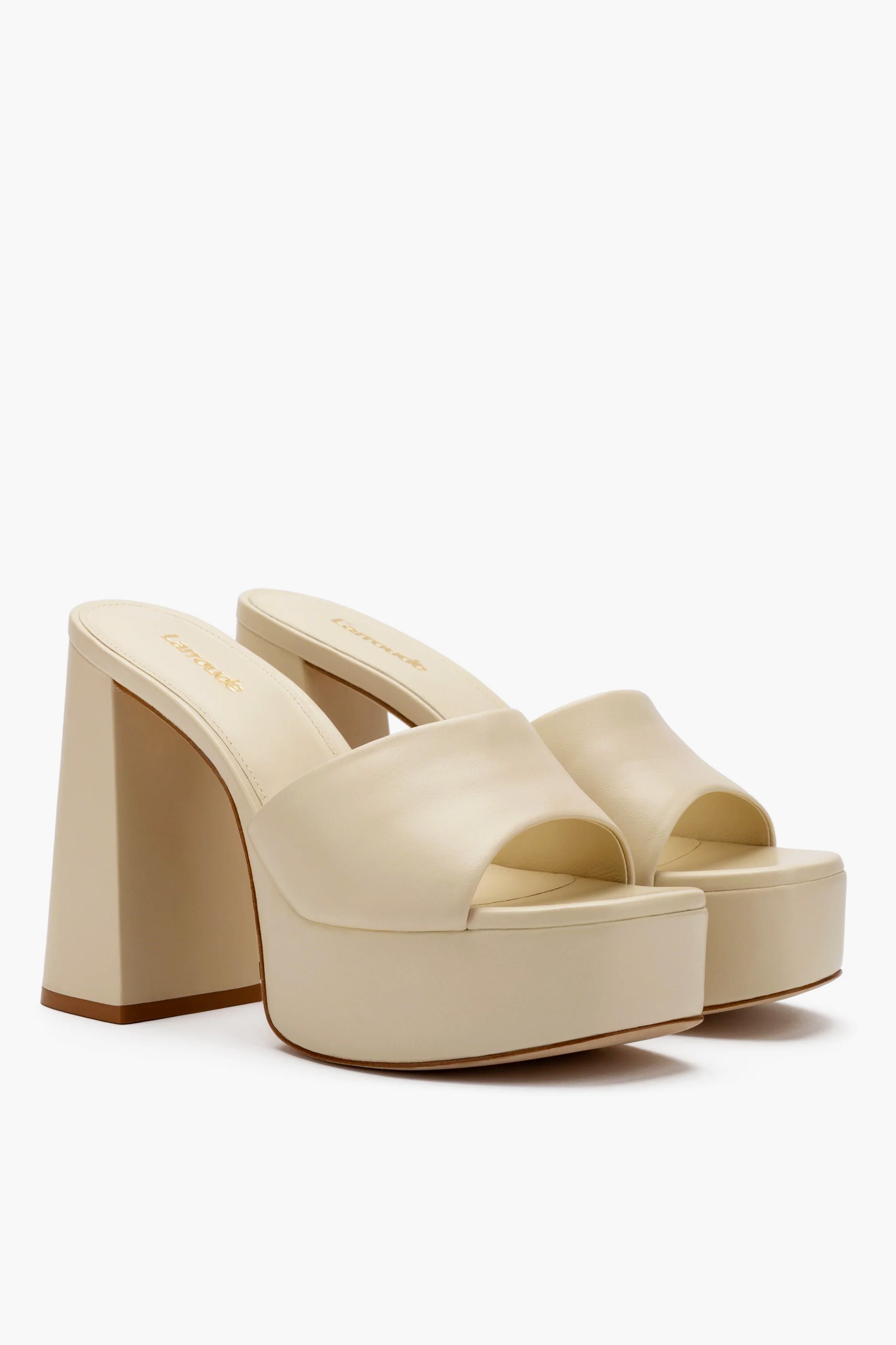 Larroude’s Ivory Dolly Mules feature cream platform leather, thick block heels, and open toes, all beautifully handmade in Brazil.