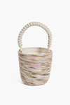 Cesta Collective’s handwoven basket bag features pastel stripes and a thick braided handle, sustainably crafted by skilled female artisans.