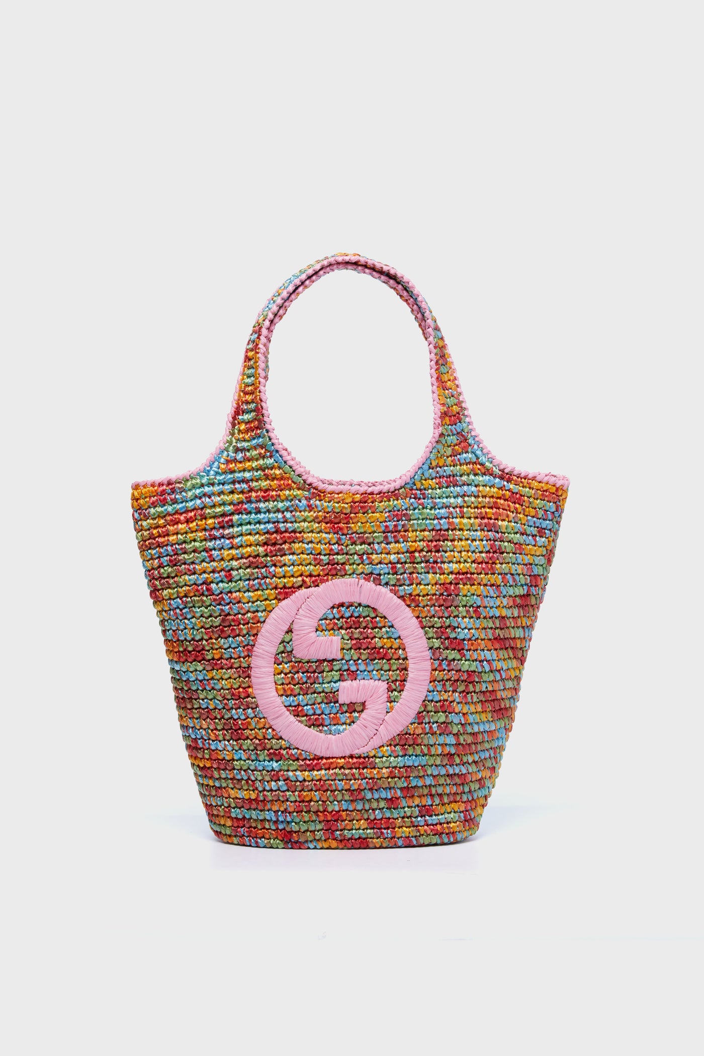 A multicolor woven tote with pink handles and a large pink Tuckernuck logo on the front, this Tuckernuck Archive Collection Raffia Effect Bag showcases the brand's signature style.