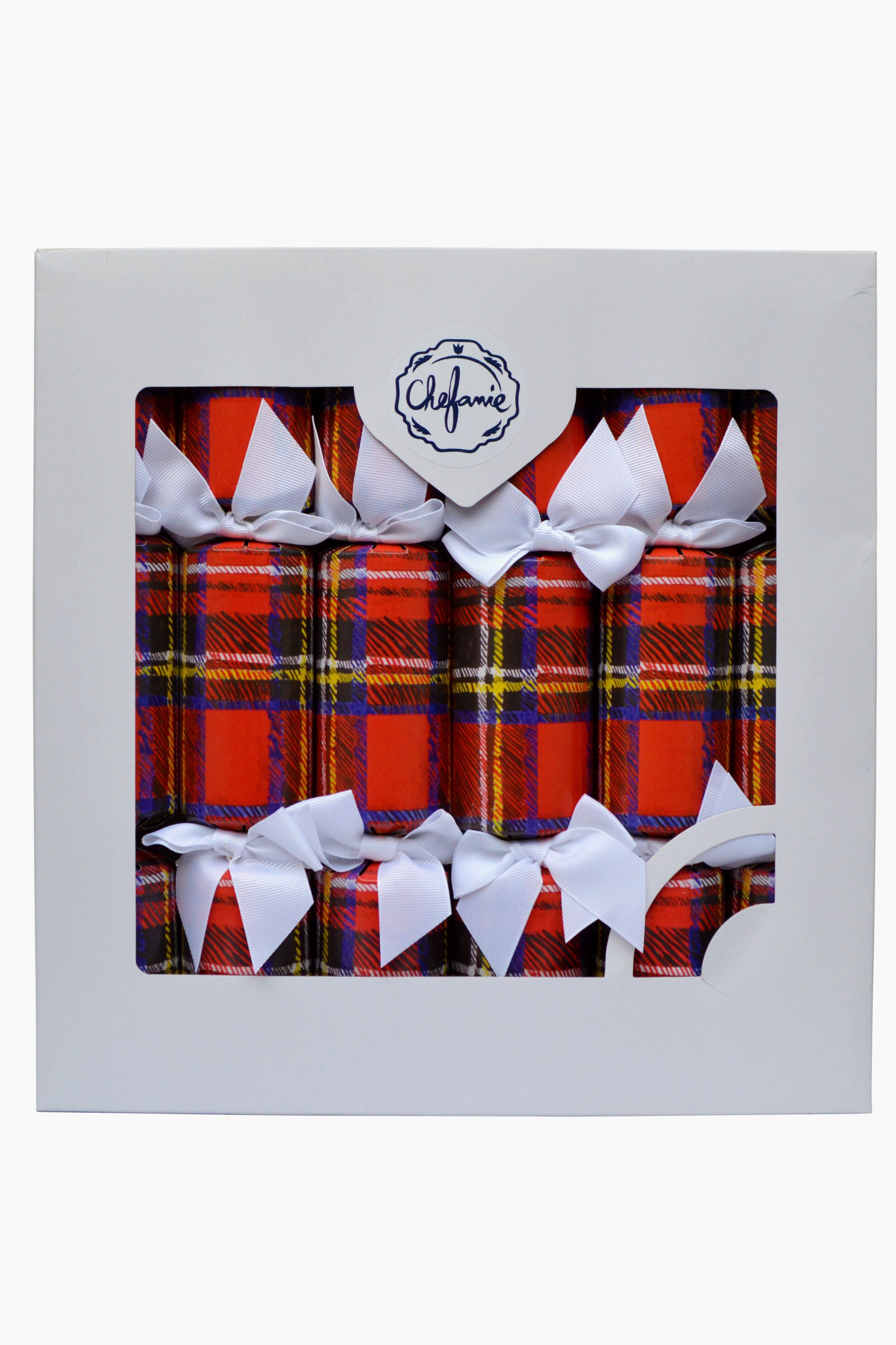 A box of six Chefanie Plaid Poppers Christmas crackers features red tartan patterns and white bows, packaged in white with a clear window and label—perfect as festive party favors for your holiday table.