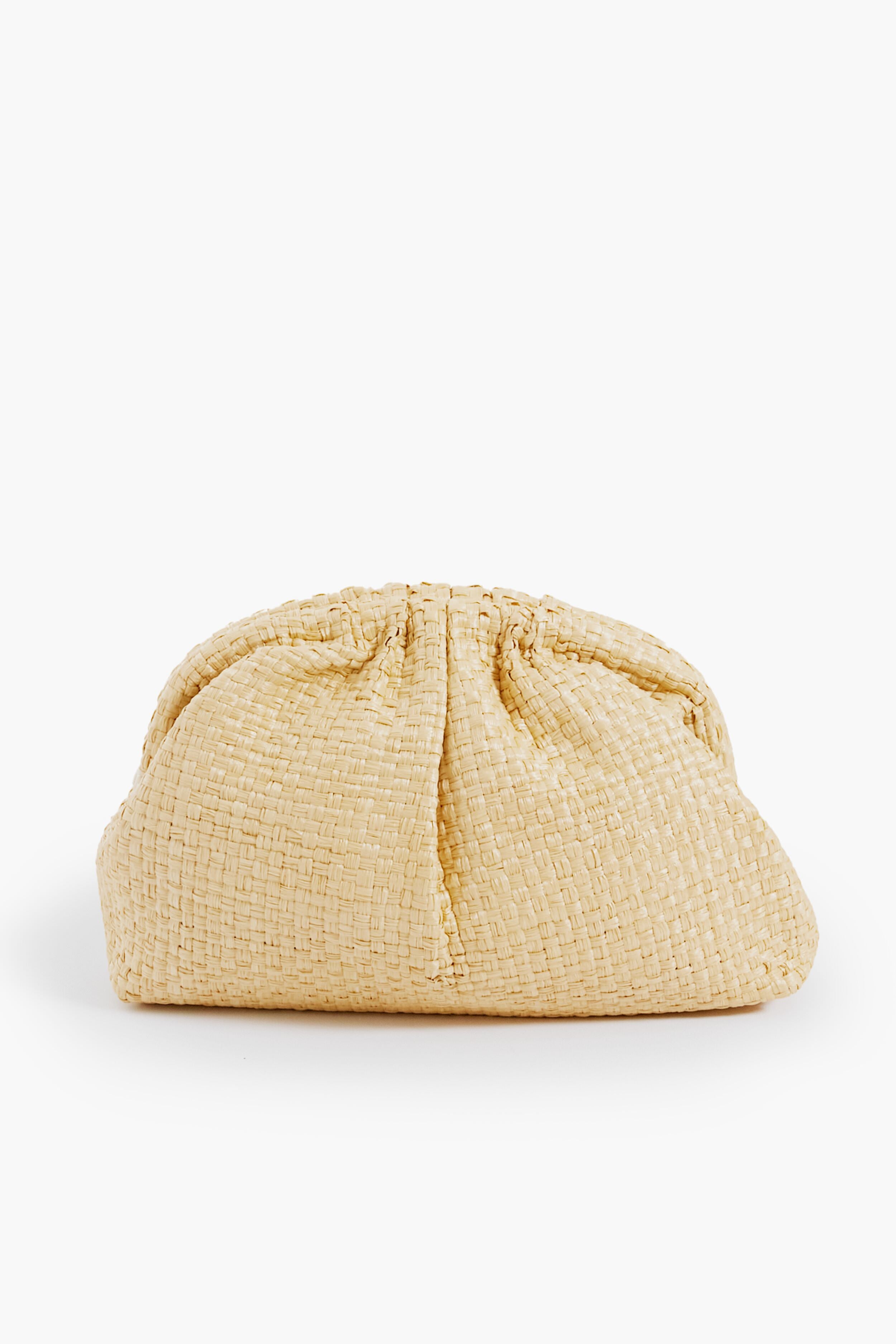 A beige handwoven raffia clutch by Maria La Rosa, featuring a soft gathered top and exceptional Italian craftsmanship.