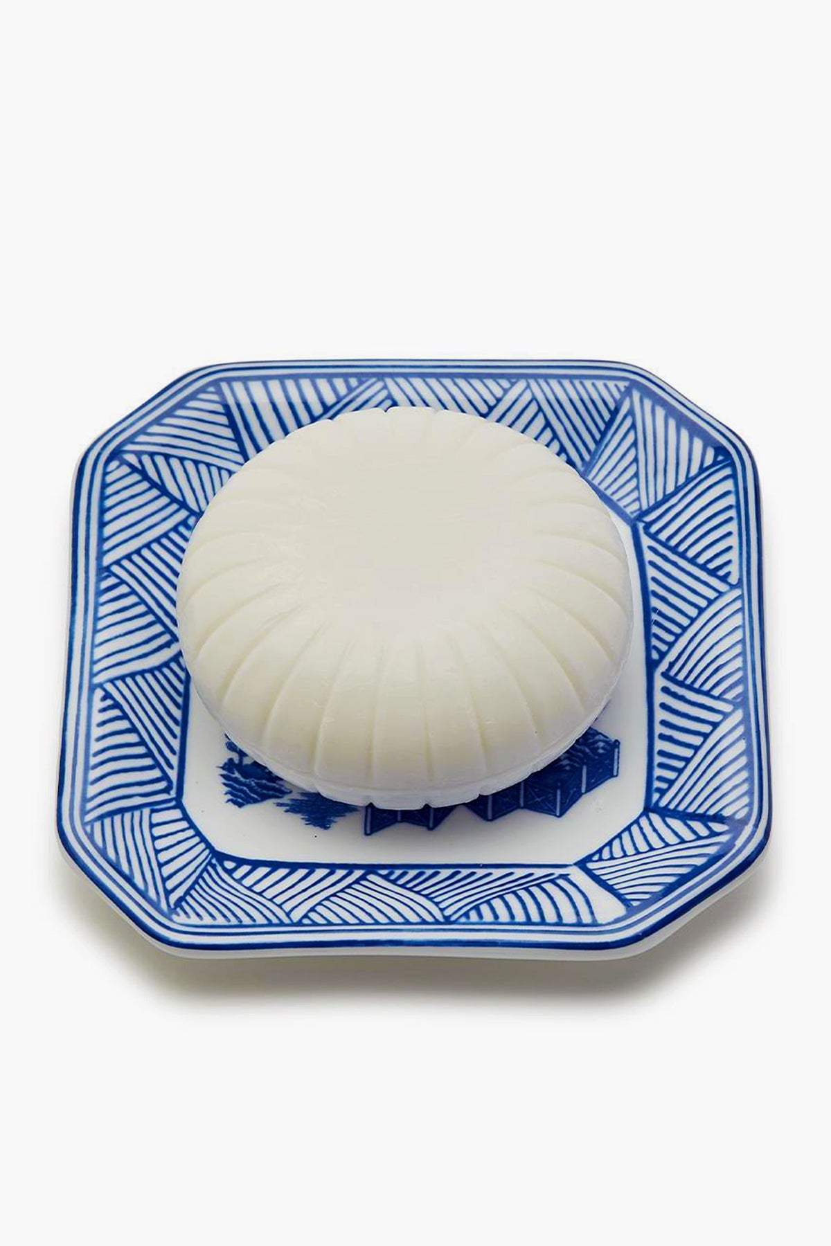 A Porcelain Tray by Two's Company holds a white object, accented with a hint of Sandalwood Scent.