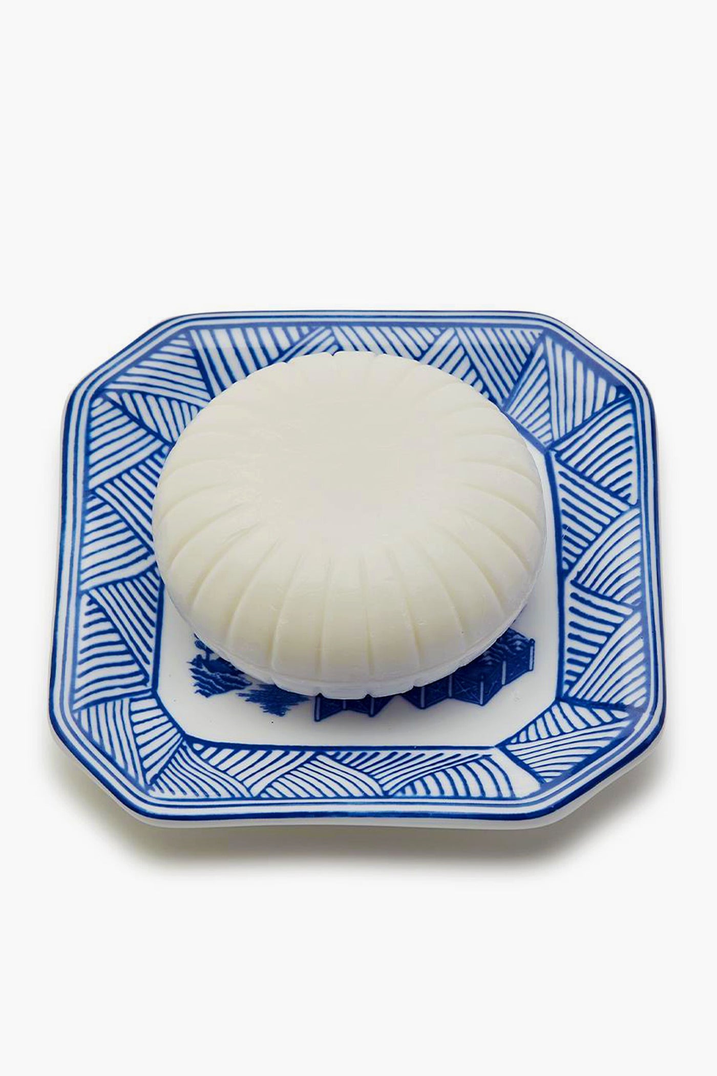 A Porcelain Tray by Two's Company holds a white object, accented with a hint of Sandalwood Scent.