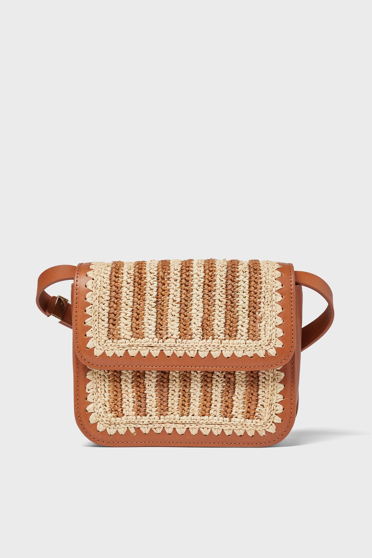 A small brown Loeffler Randall Kenton crossbody bag with a leather base, woven beige and brown flap, shoulder strap, and decorative stitching.