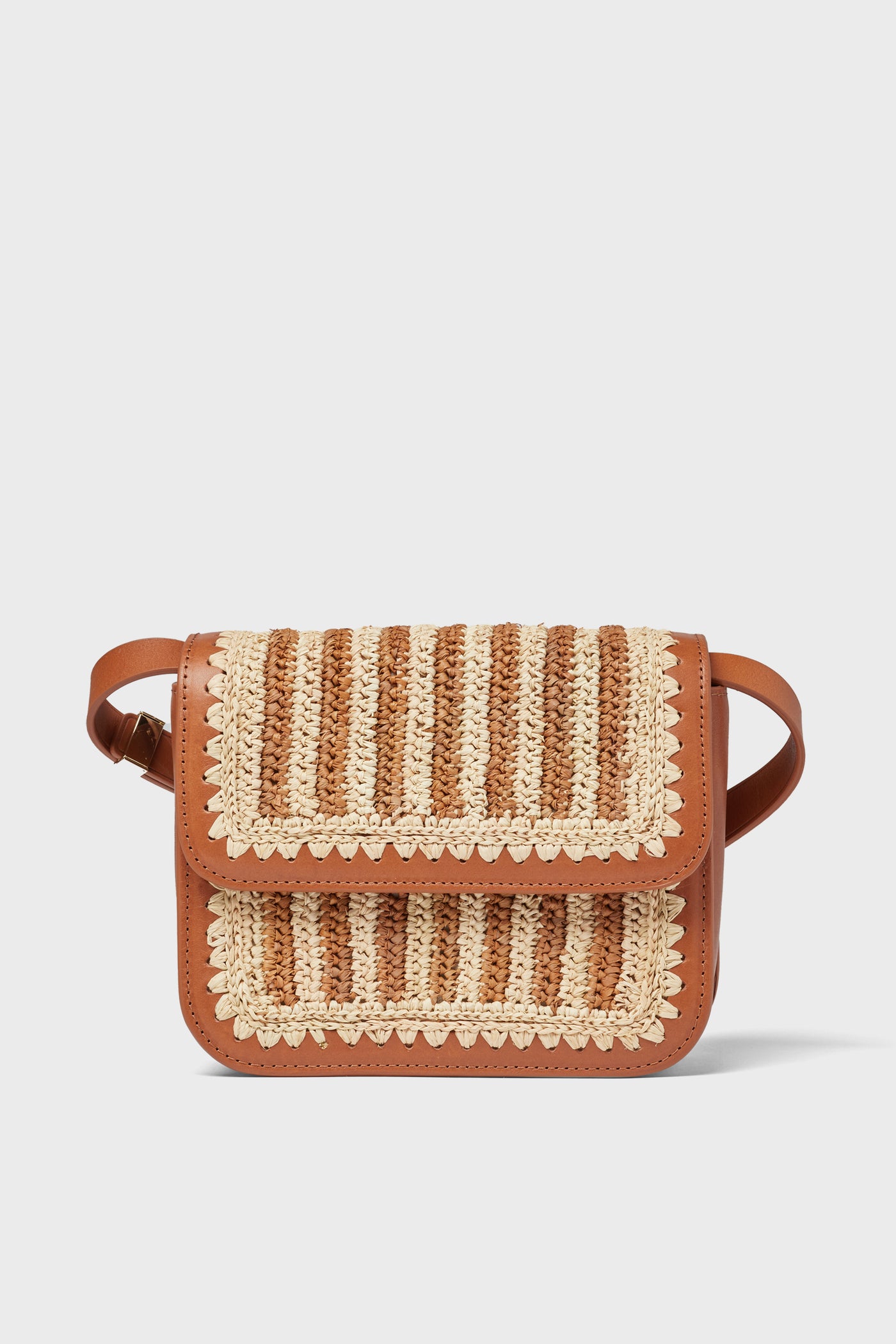 A small brown Loeffler Randall Kenton crossbody bag with a leather base, woven beige and brown flap, shoulder strap, and decorative stitching.