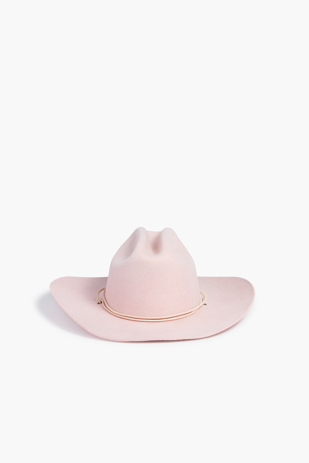 A light pink wide-brimmed cowgirl hat by Hampui Hats features a simple band around the crown, perfect for those seeking custom-made Barbie-core style.