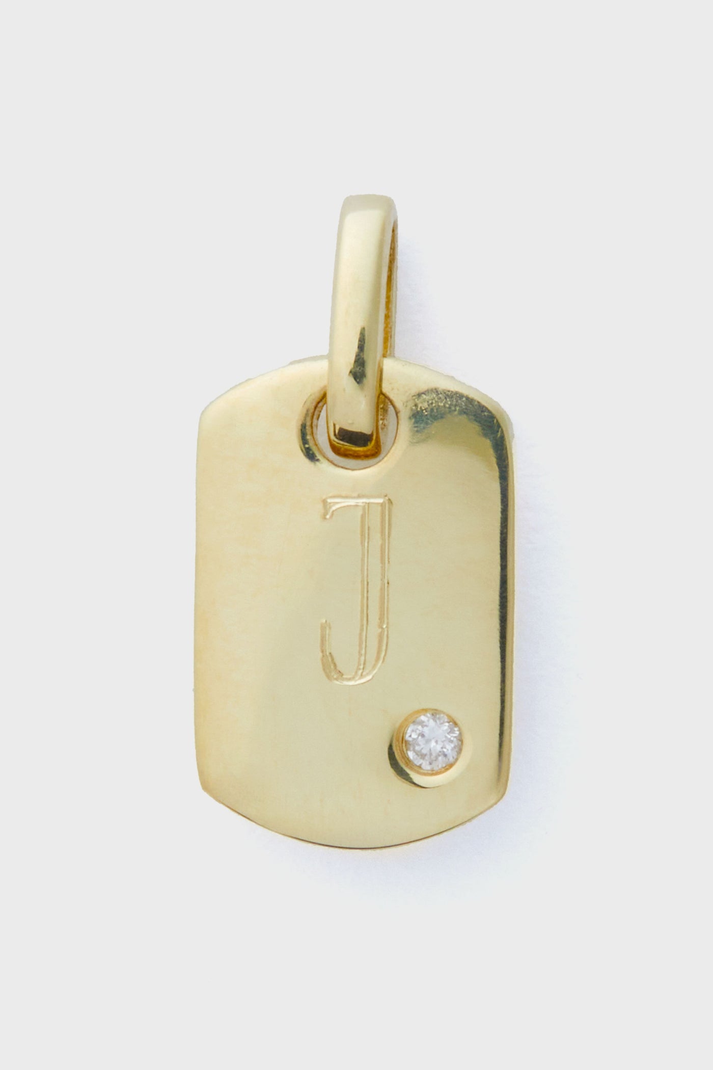 Tuckernuck Fine Jewelry 14k gold rectangular pendant features an engraved letter J and a small round diamond at the bottom right, crafted as a dog tag charm with a bail.