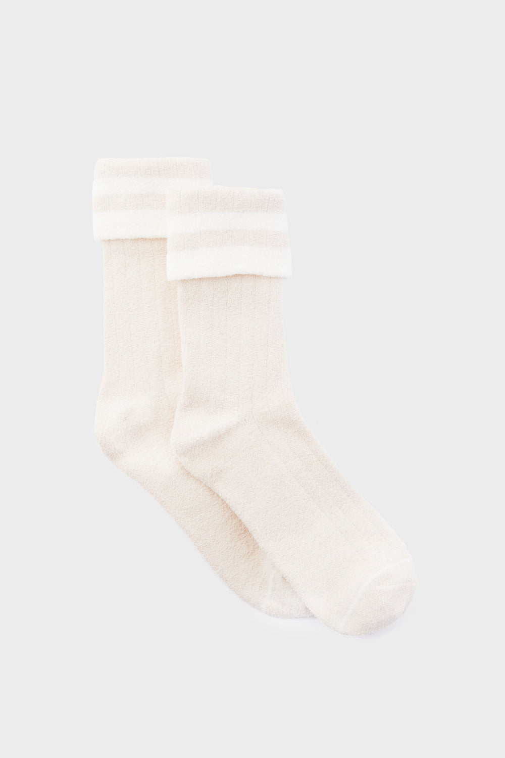 A pair of white Varley crew socks featuring a cozy ribbed design, folded cuff, and two horizontal stripes near the top for a classic look.