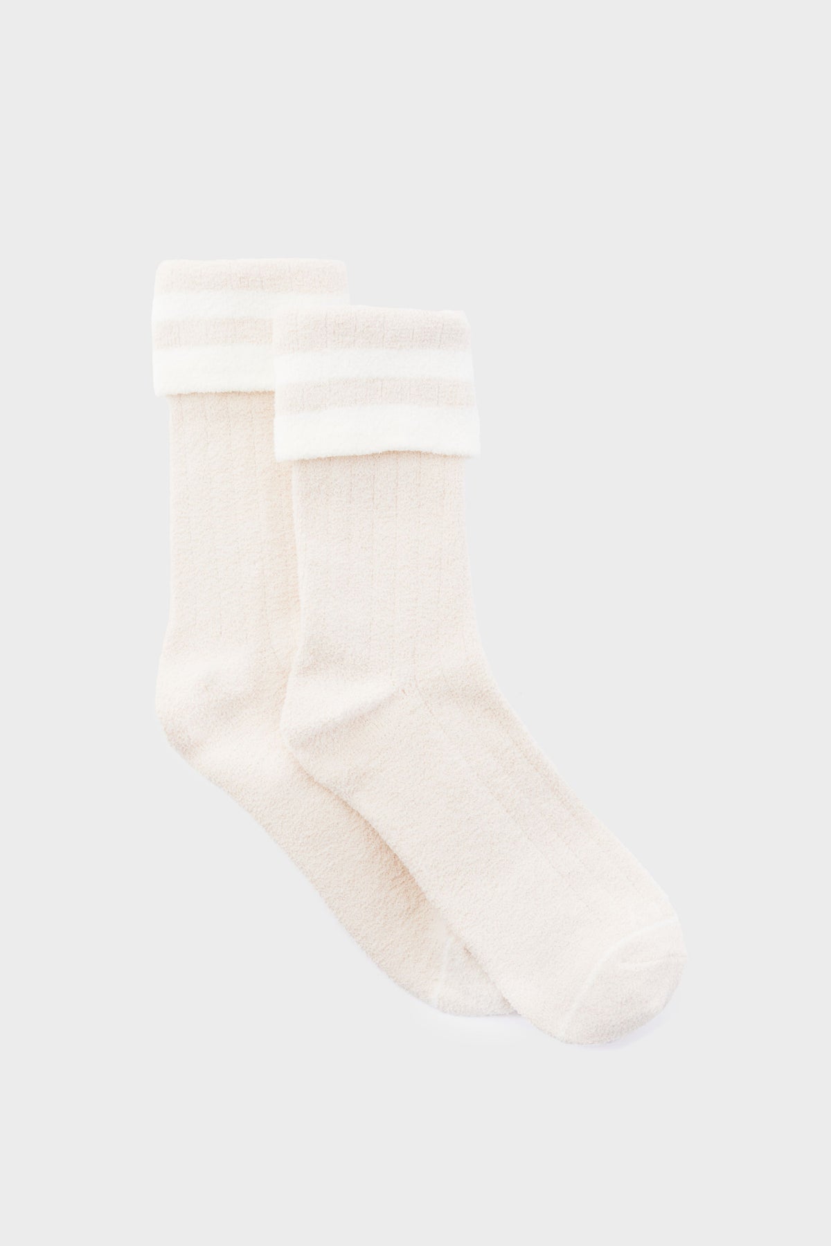 A pair of white Varley crew socks featuring a cozy ribbed design, folded cuff, and two horizontal stripes near the top for a classic look.