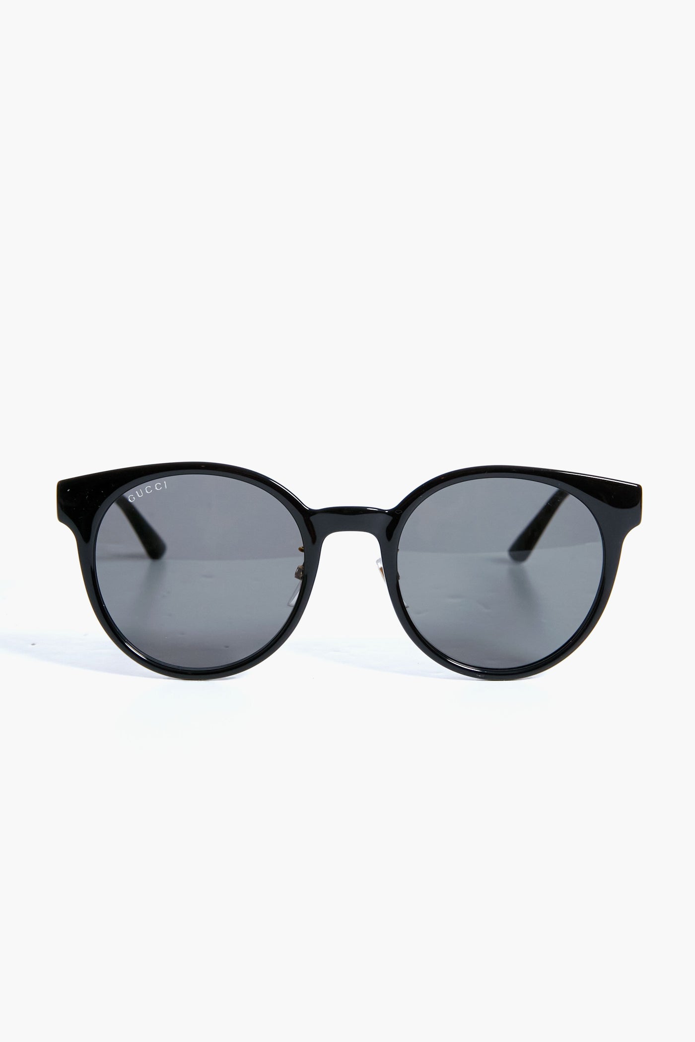 Gucci black round sunglasses with dark lenses and straight arms, featuring a stylish round frame and luxury fashion appeal.