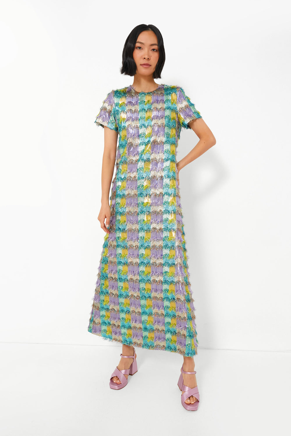 A woman wears a La DoubleJ Pharaoh Swing Dress with a colorful geometric jacquard pattern and light purple platform heels.