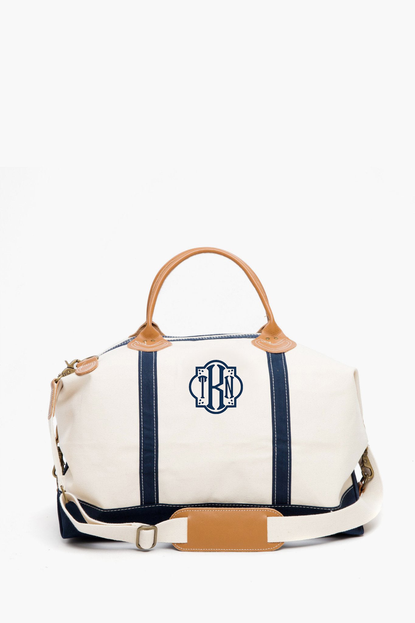 CB Station’s eco-friendly cotton canvas satchel features navy blue stripes, tan leather handles, a detachable shoulder strap, and a blue monogram logo on the front.