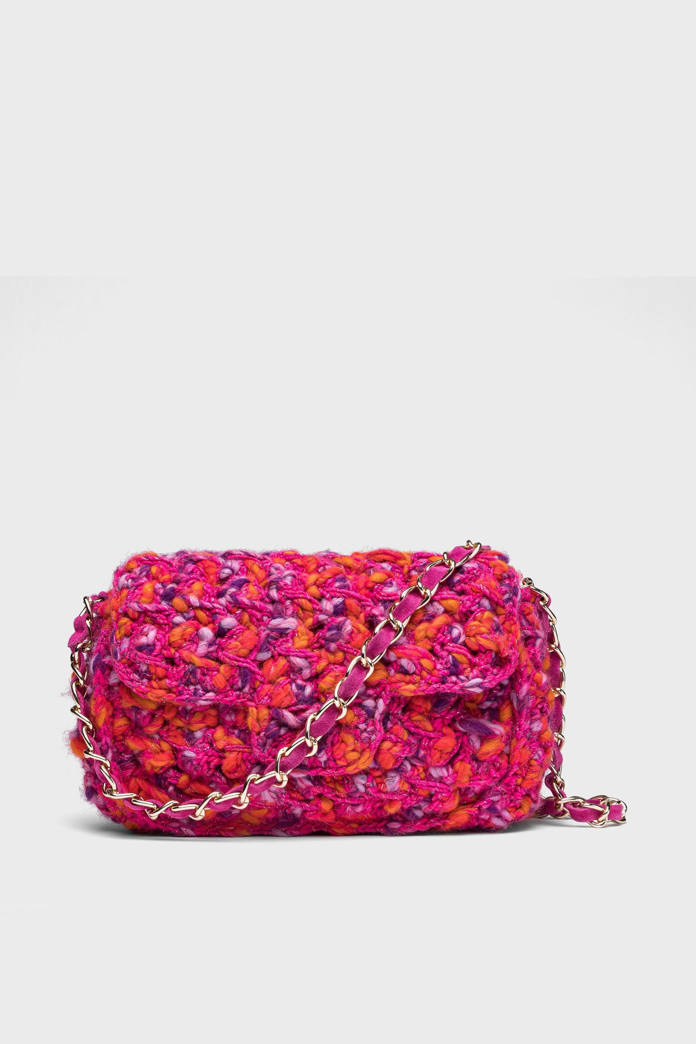 The Caterina Bertini bag is a small Italian handmade accessory with a crocheted texture in vibrant pink, orange, and purple shades, finished with a silver chain strap.