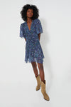 Woman wearing the Isabel Marant Etoile Midnight Vivienne Printed Chiffon mini dress with flutter sleeves and tan cowboy boots, channeling an Isabel Marant-inspired style.