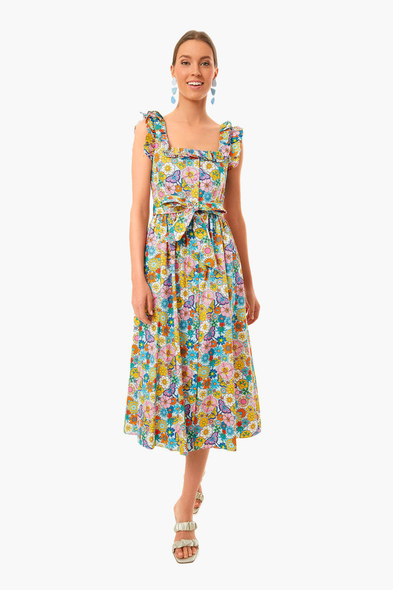 A woman wears a Borgo de Nor sleeveless, square-neck floral midi dress with ruffled straps and waist tie, styled with drop earrings and sandals.