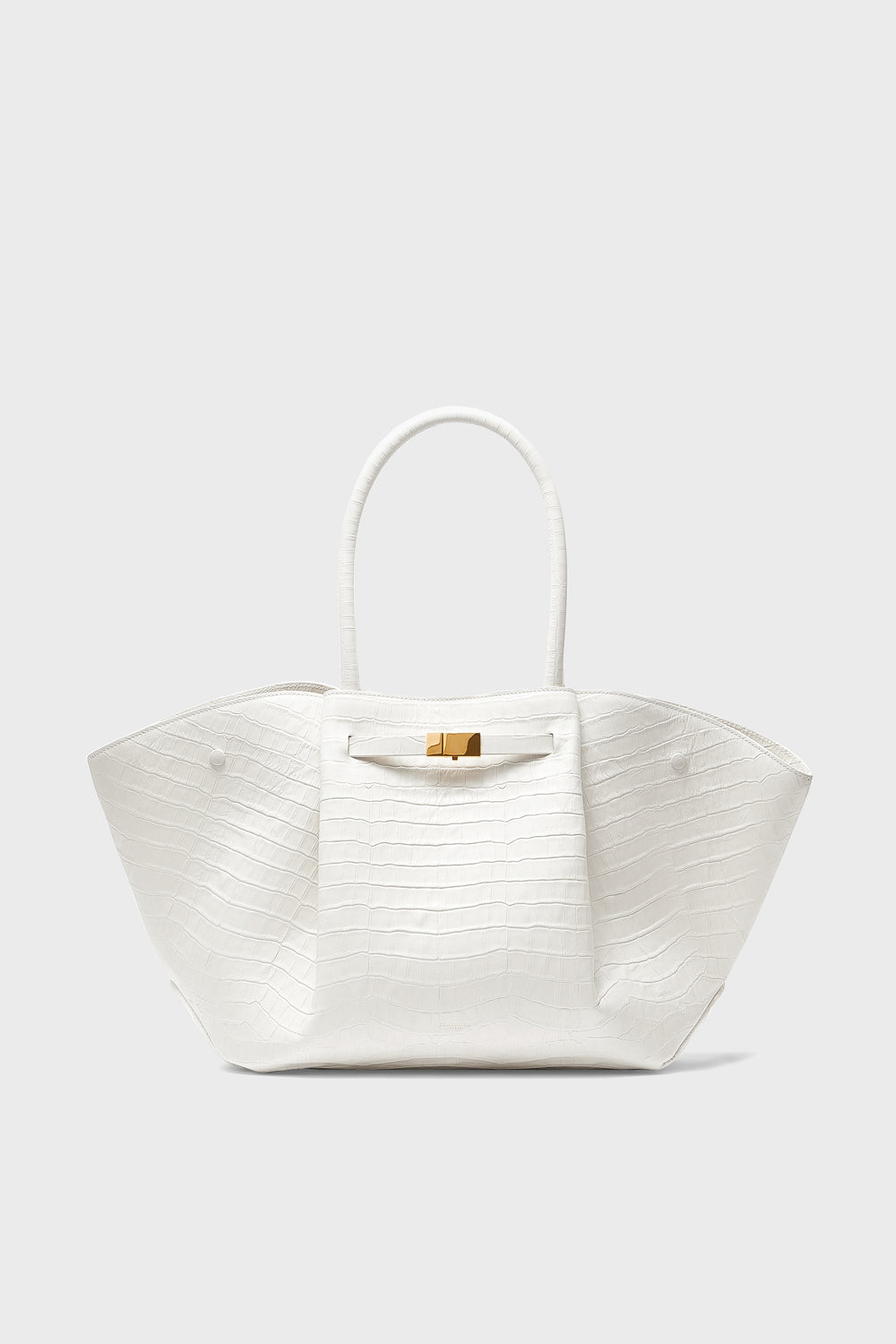 A white, croc-effect leather handbag by Demellier with two handles and a gold clasp, embodying the elegance of handcrafted Spanish design.