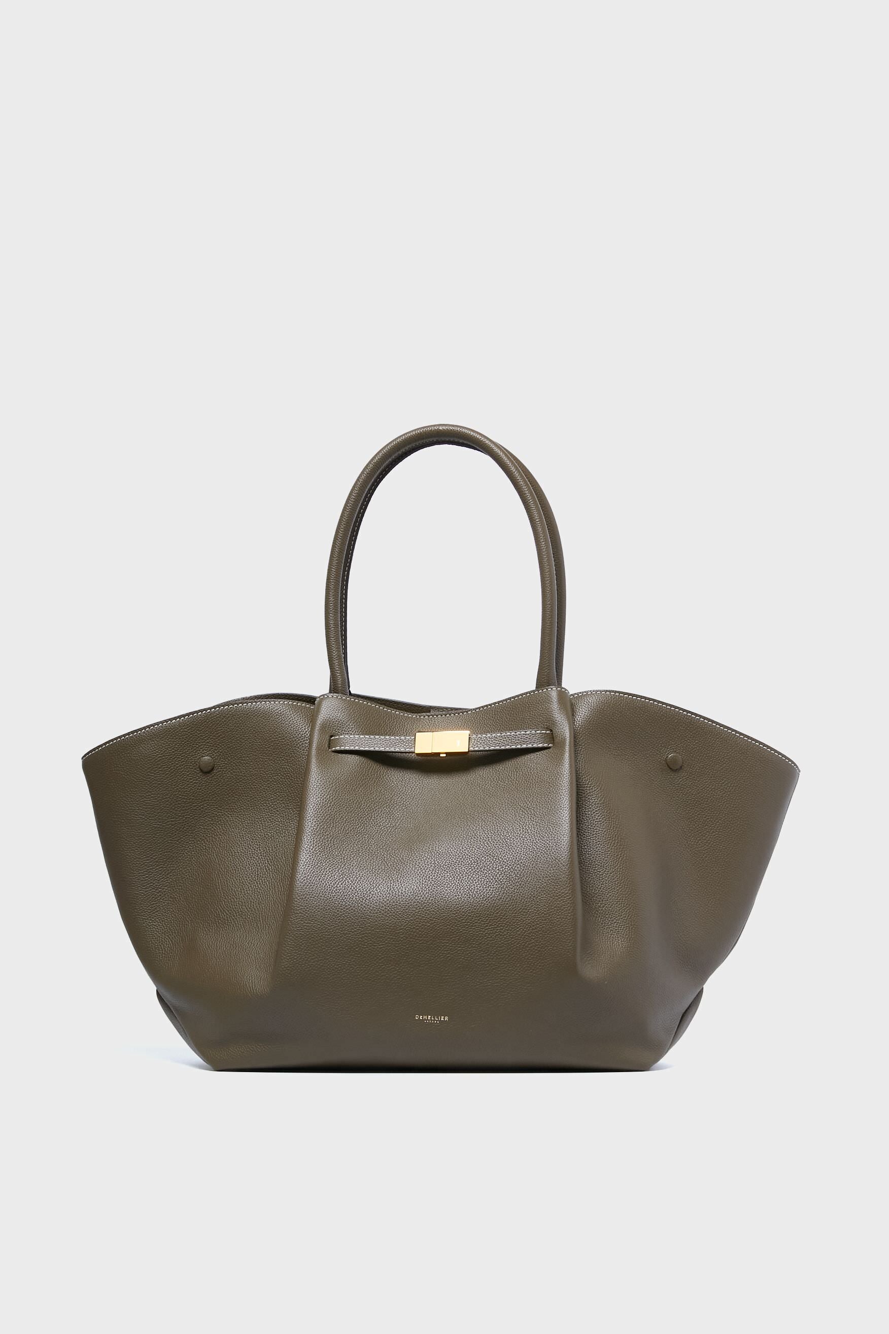 The Demellier olive green handcrafted leather tote features two rounded handles, winged sides, and a gold-tone clasp—a stylish, sustainable accessory for eco-conscious fashion lovers.