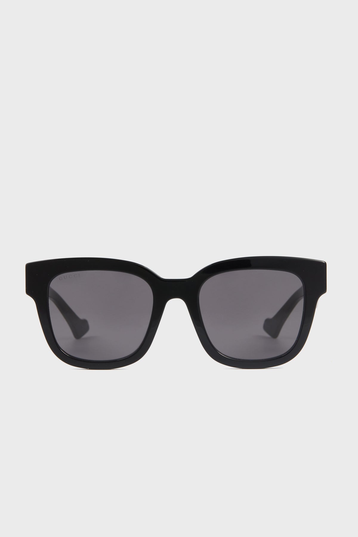 Black rectangular Gucci sunglasses with dark lenses, seen from the front, add luxury fashion appeal to classic square frames.