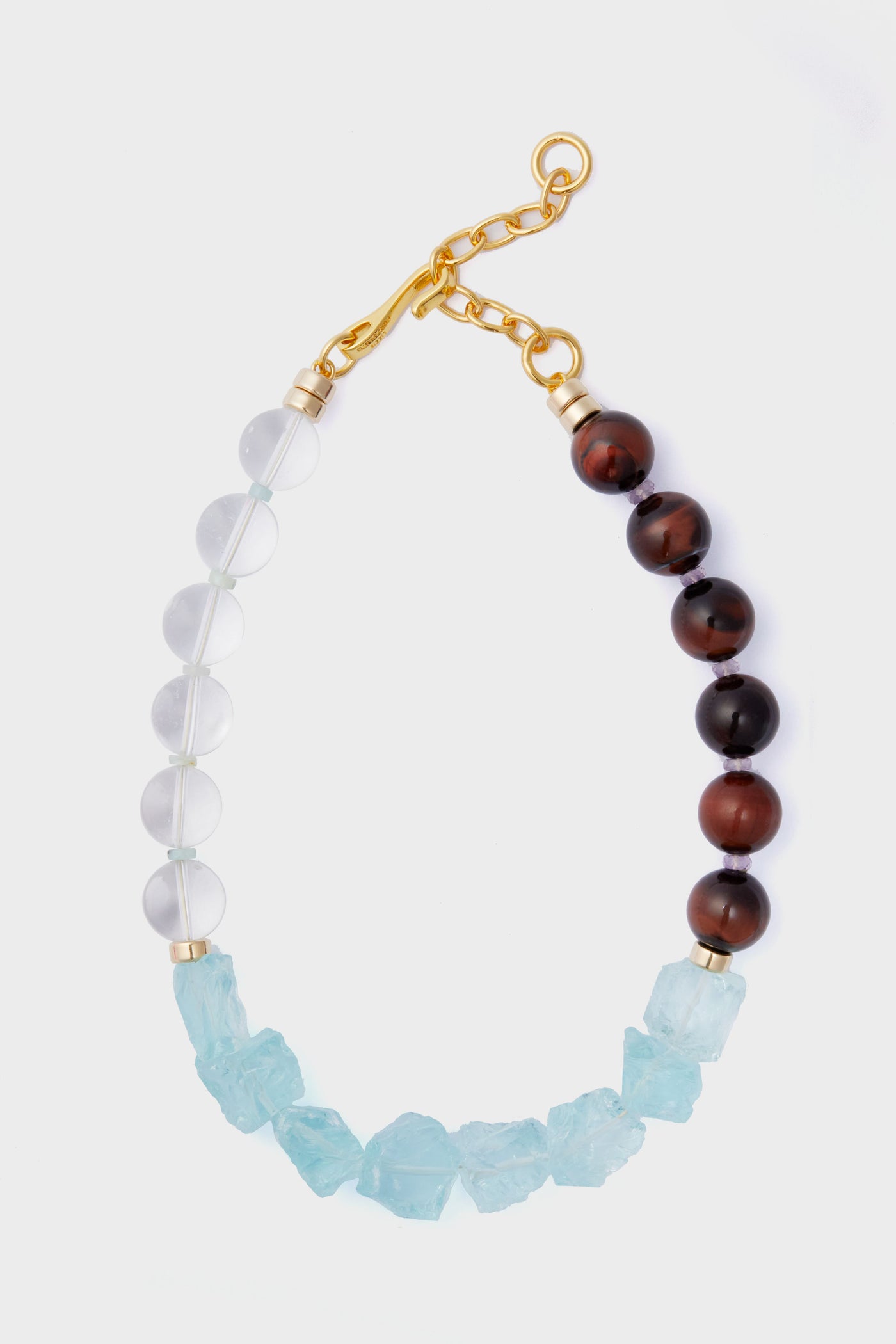 The Lizzie Fortunato necklace features alternating clear and brown round beads, irregular light blue stones, and is finished with a gold chain and clasp.