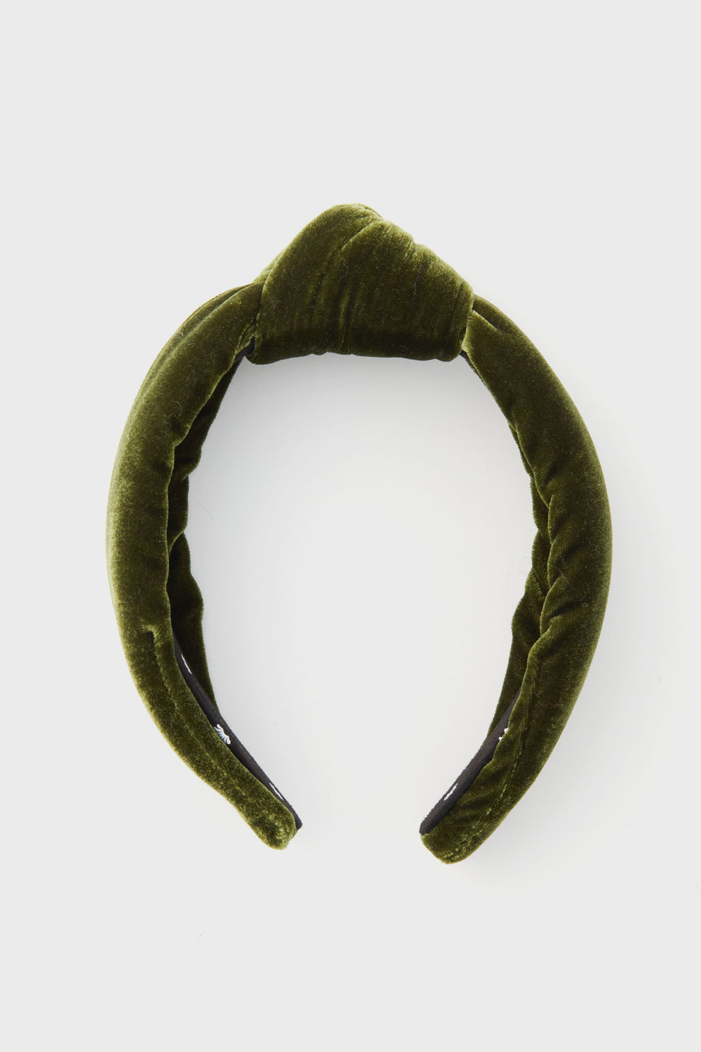 A green velvet padded headband by Lele Sadoughi, inspired by the brand’s signature style, is displayed simply.