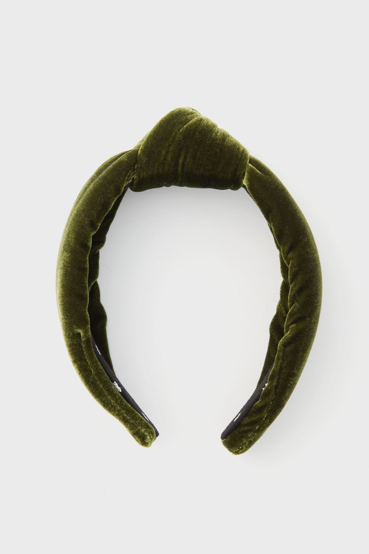 A green velvet padded headband by Lele Sadoughi, inspired by the brand’s signature style, is displayed simply.