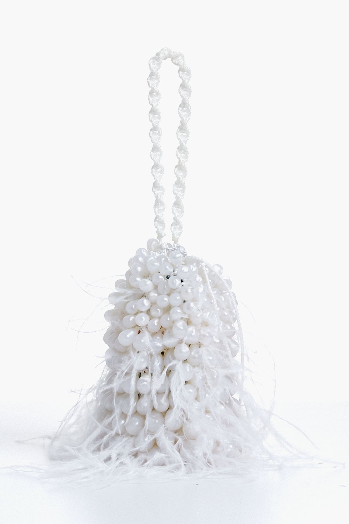 The Cult Gaia white beaded evening bag features a beaded handle and feathery white fringes at the base, making it the perfect feather wristlet for special occasions.