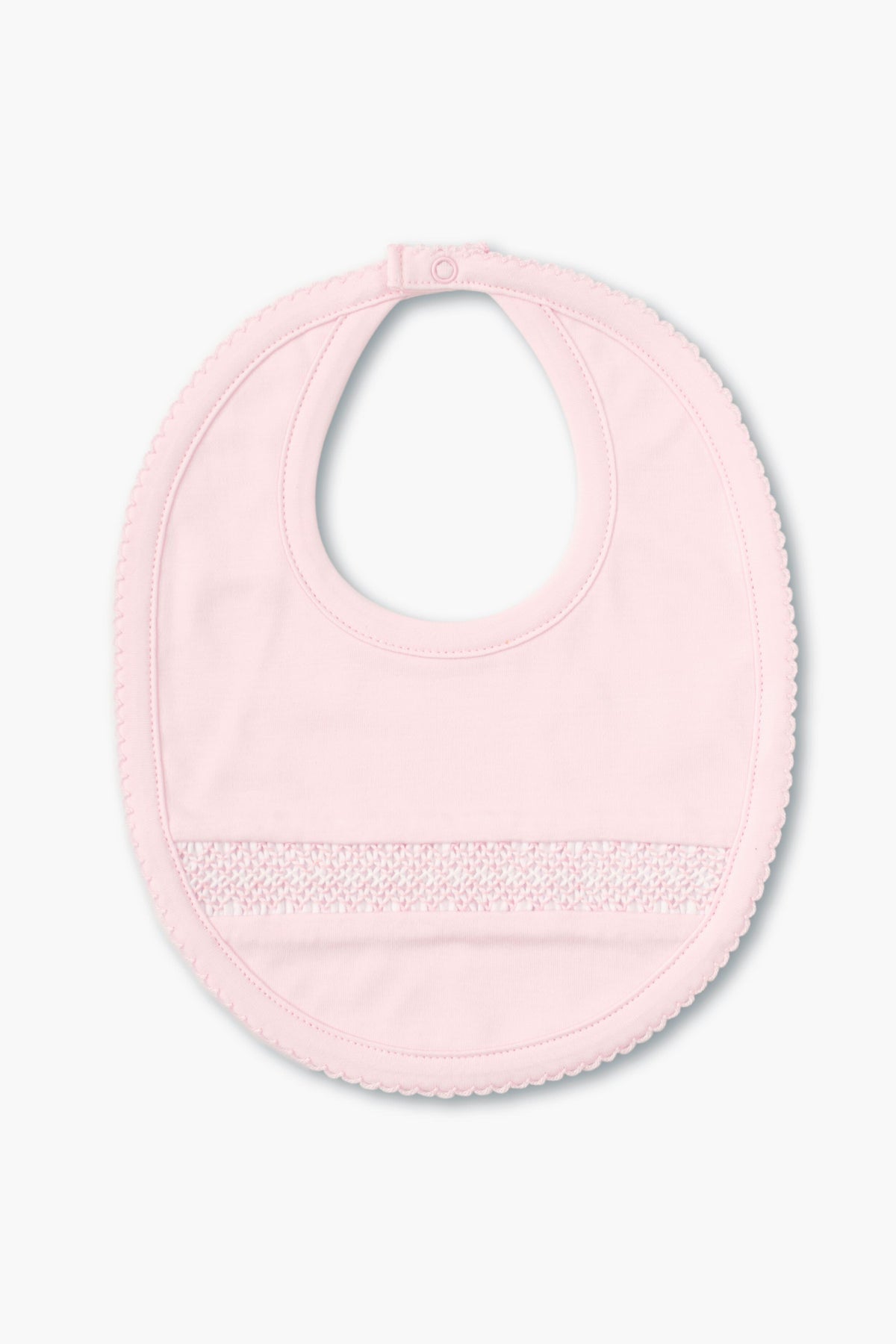 The kissy kissy light pink hand-smocked baby bib features a snap closure, delicate front detailing, and is crafted from soft pima cotton.