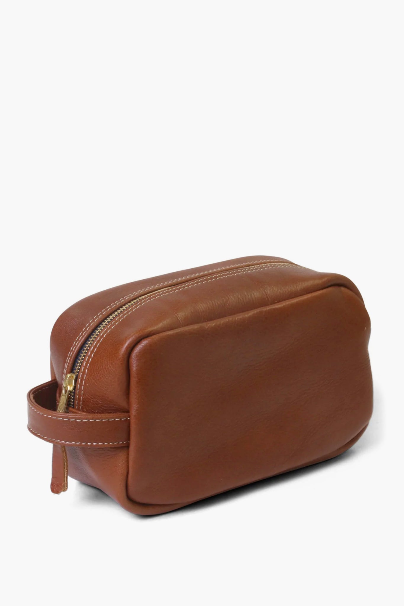 The Hudson Sutler brown leather shave kit features a zipper and side handle, making it a perfect travel toiletry organizer.