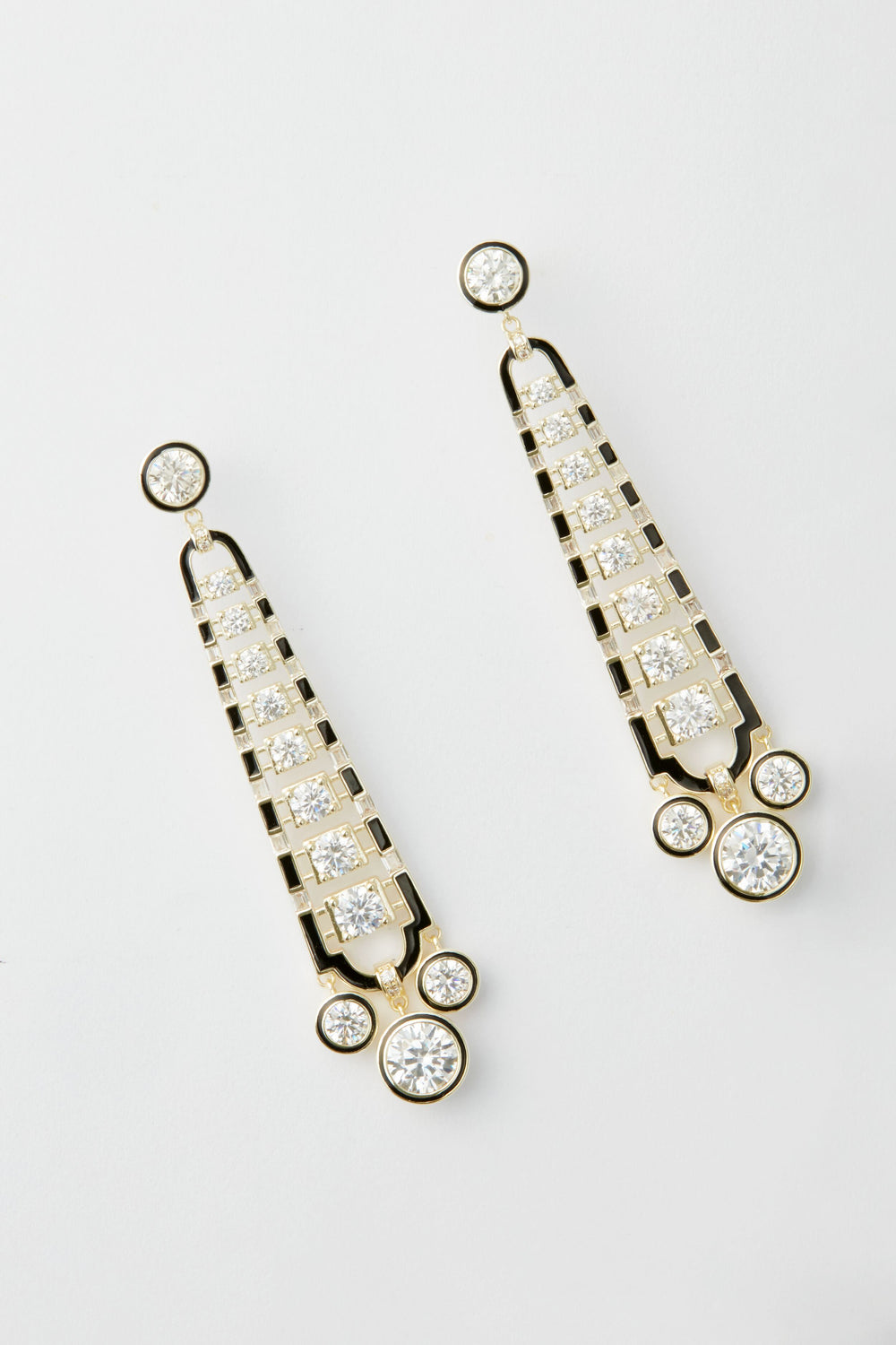 A pair of gold and black art deco earrings by Nicola Bathie, featuring multiple round and square clear gemstones arranged in a symmetrical, vintage-inspired design.