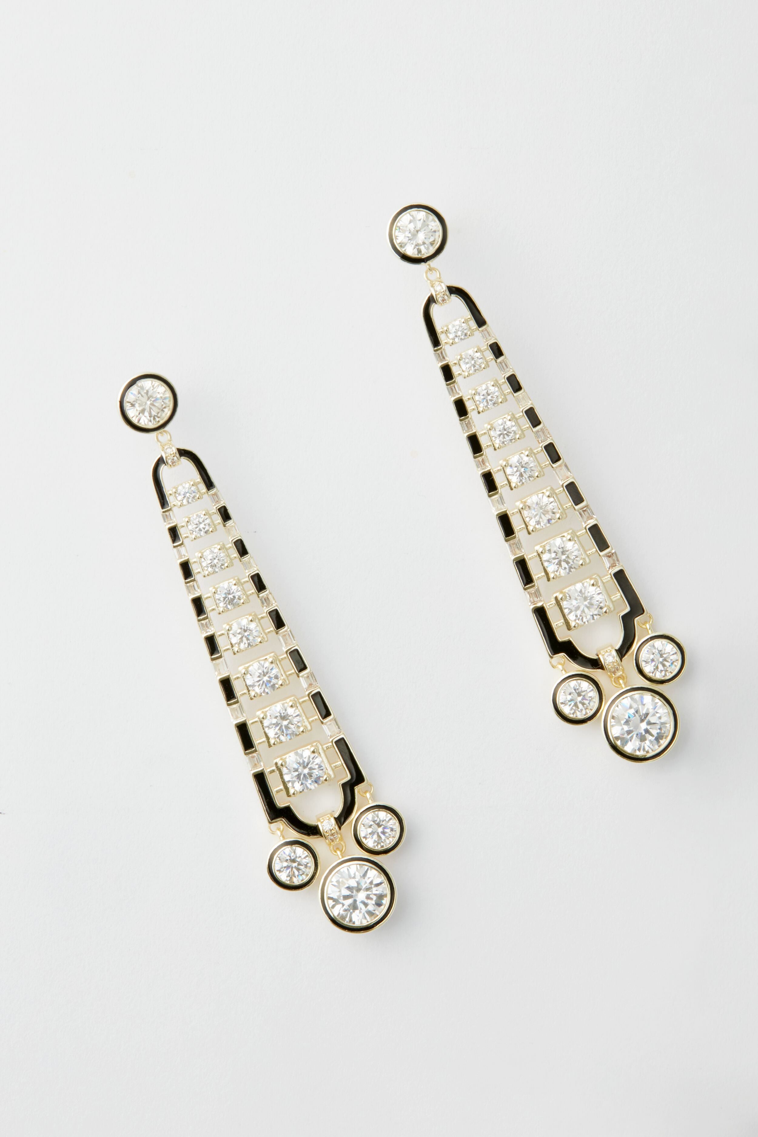 A pair of gold and black art deco earrings by Nicola Bathie, featuring multiple round and square clear gemstones arranged in a symmetrical, vintage-inspired design.