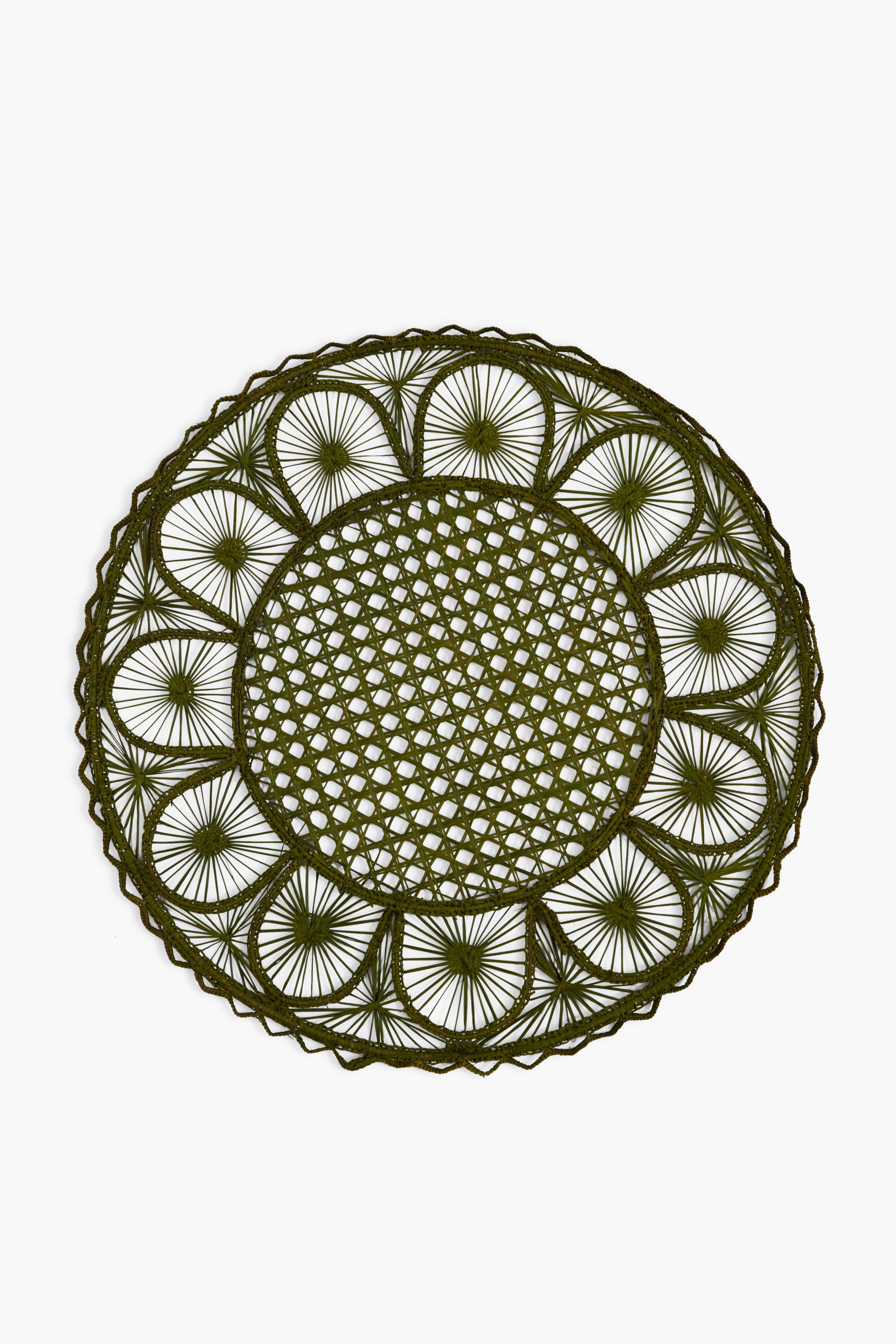 The Coro Cora round placemat is handmade by Colombian artisans using natural fibers, featuring an open lattice weave and green circular pattern for a unique, artisanal touch.