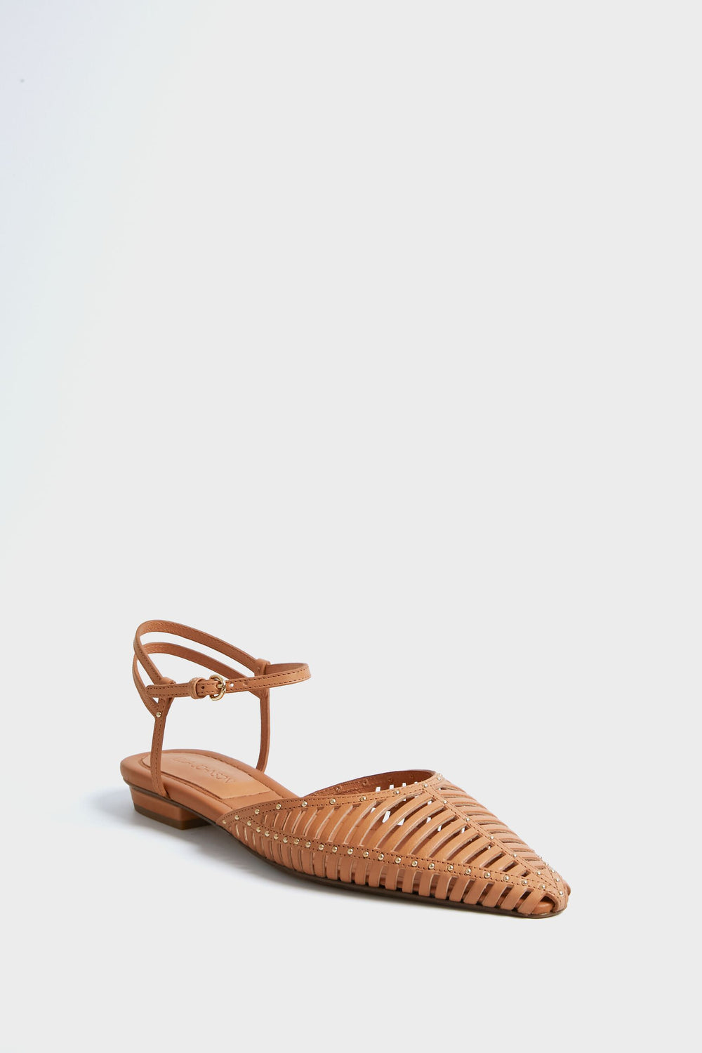 A brown woven leather flat shoe with a pointed toe and ankle strap from Ulla Johnson, inspired by the Rust Cage Flats.