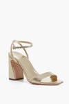 A metallic gold Champagne Malia Sandal by Loeffler Randall featuring an open toe, thick block heel, and ankle strap with buckle.