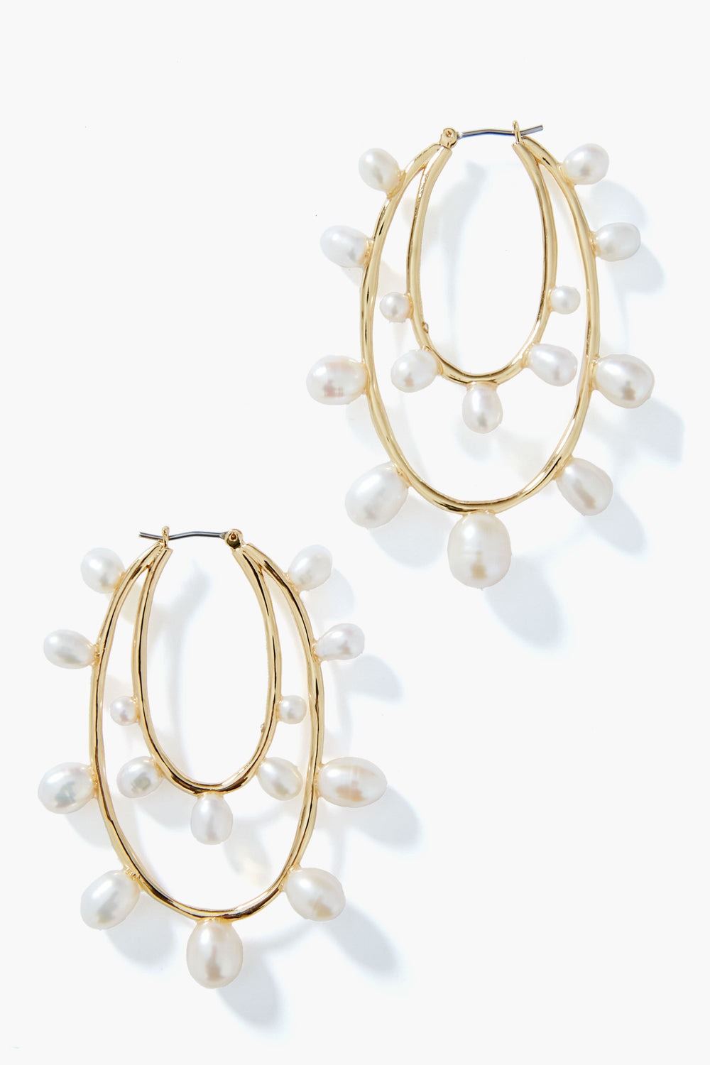 Mignonne Gavigan gold hoop earrings with two overlapping loops, each accented by evenly spaced dangling white pearls. A classic, elegant twist on pearl hoops.