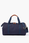 The Neely & Chloe navy blue gym duffel bag features dual handles, brown leather accents on the handles and zipper pulls, plus a detachable shoulder strap—an ideal blend of durability, function, and style for everyday use.