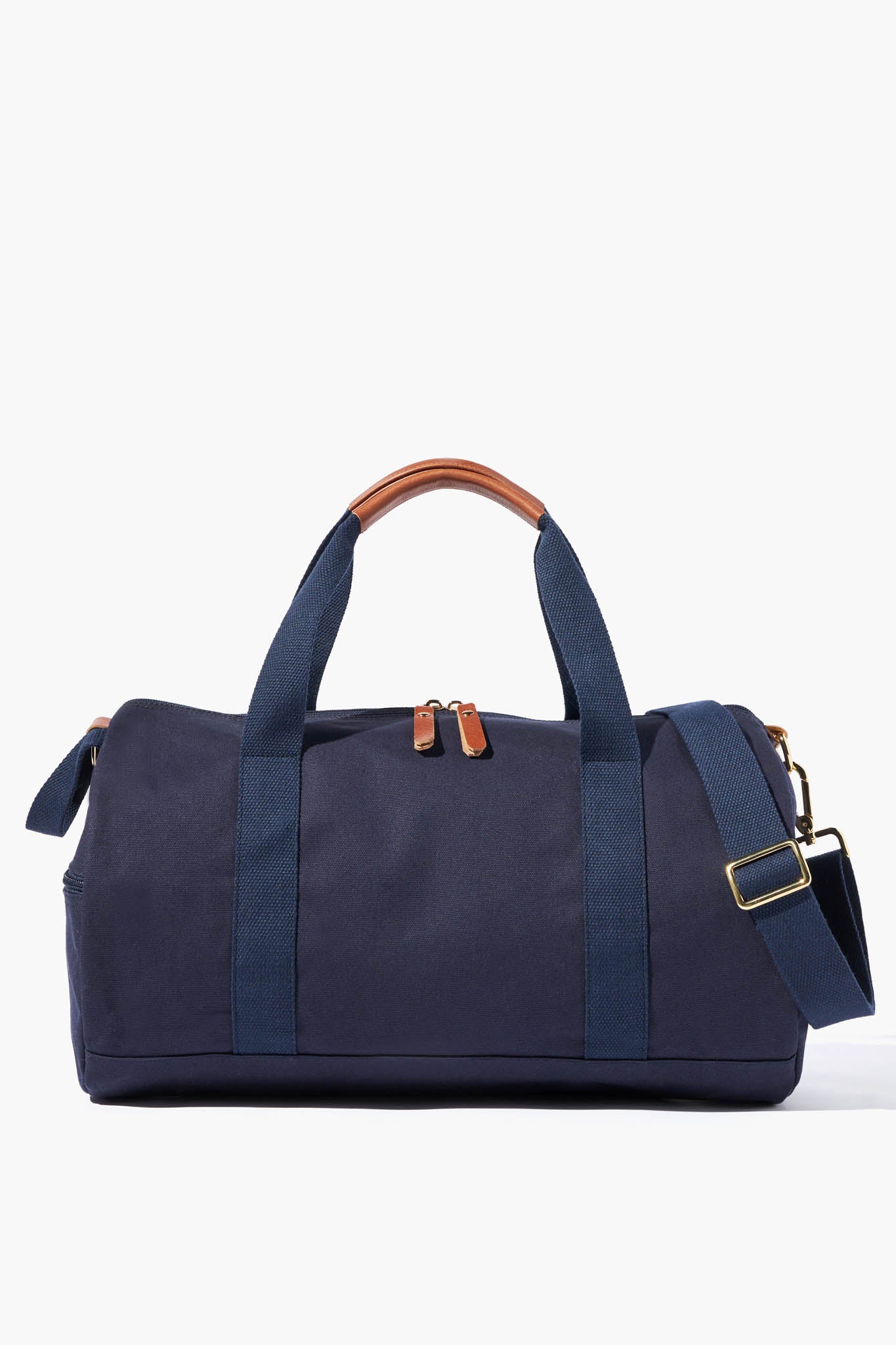 The Neely & Chloe navy blue gym duffel bag features dual handles, brown leather accents on the handles and zipper pulls, plus a detachable shoulder strap—an ideal blend of durability, function, and style for everyday use.